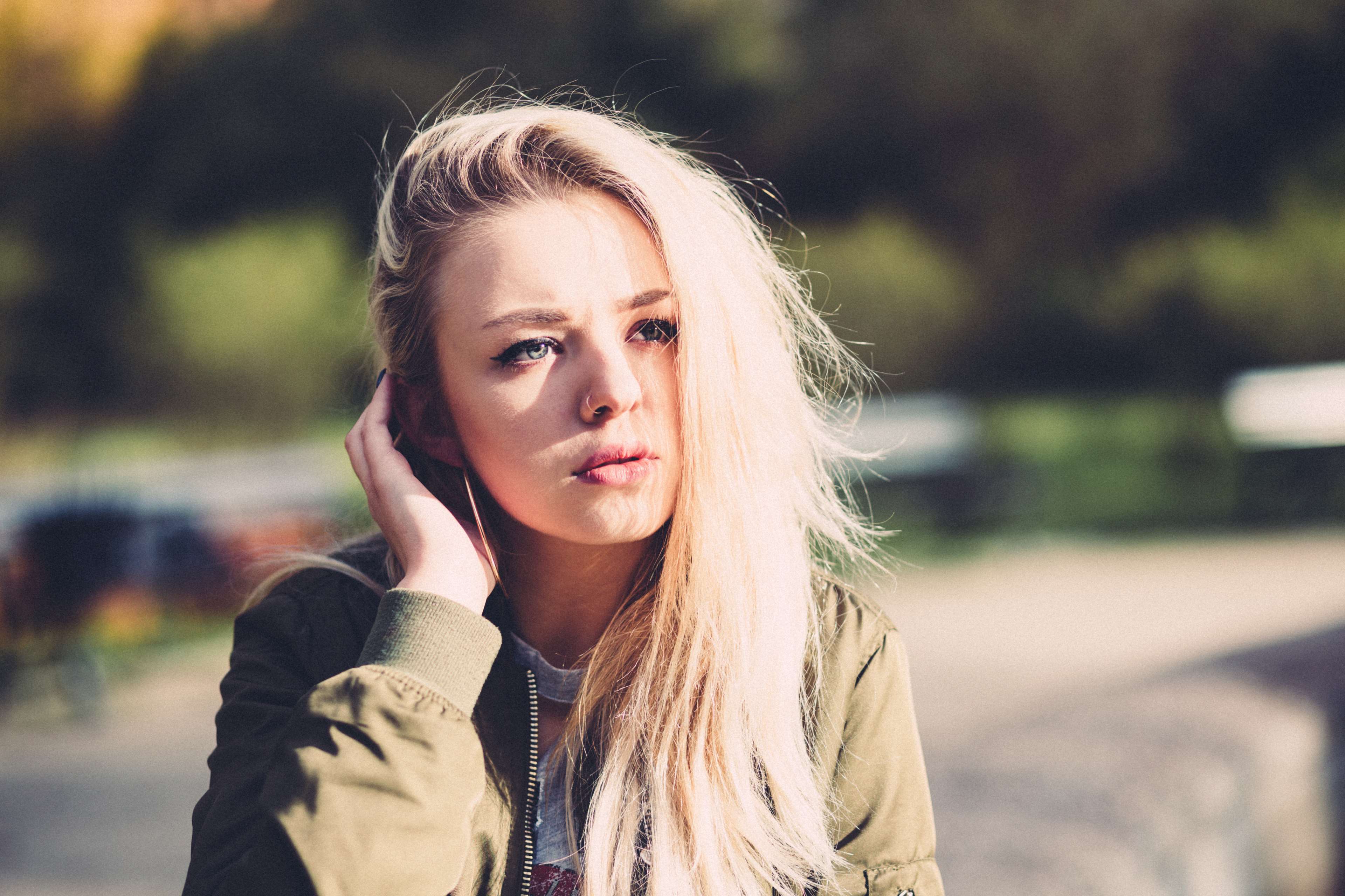 Young blonde woman in bomber jacket outdoors HD Wallpaper