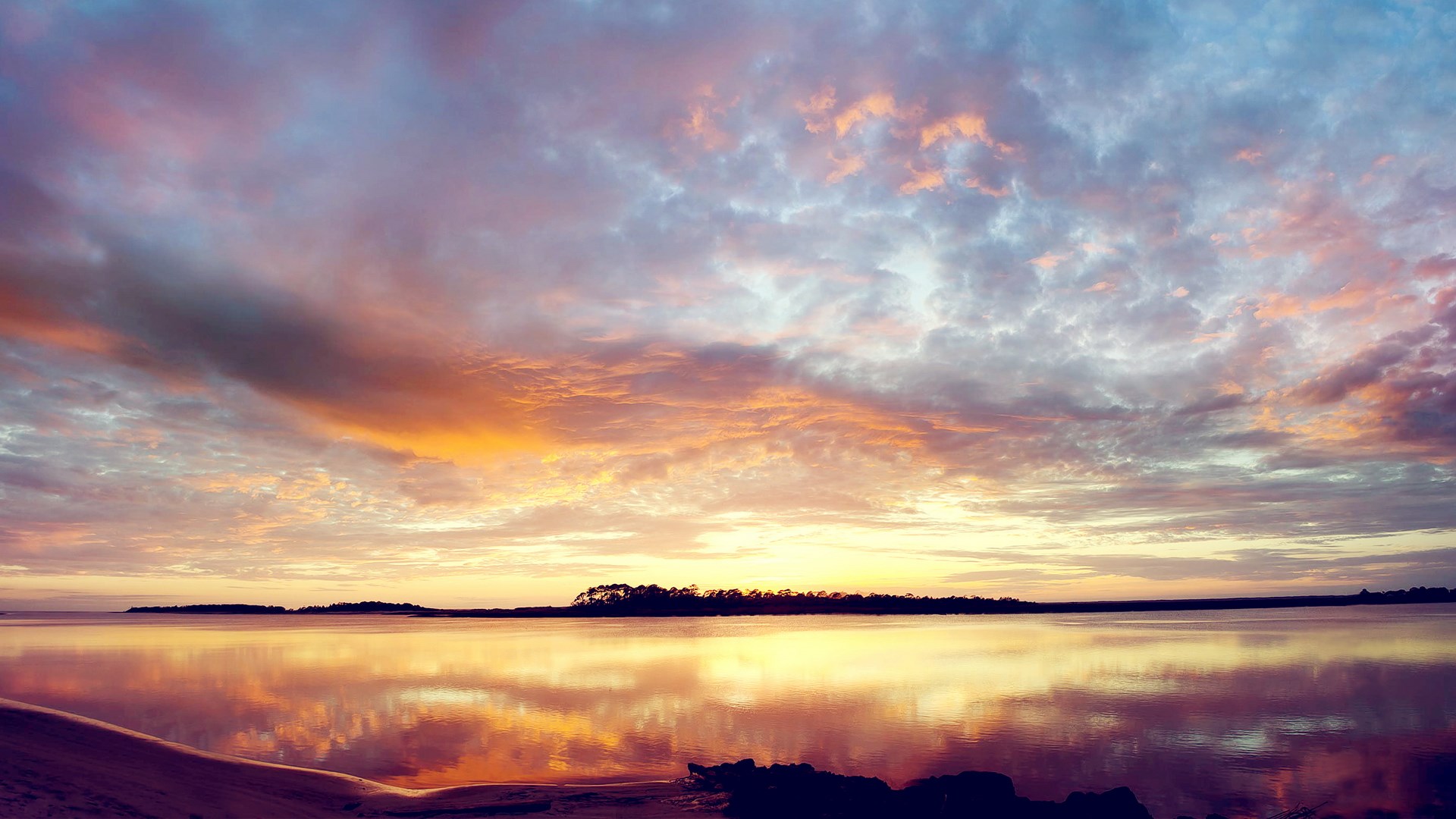 Sunset over a calm body of water with colorful clouds HD Wallpaper