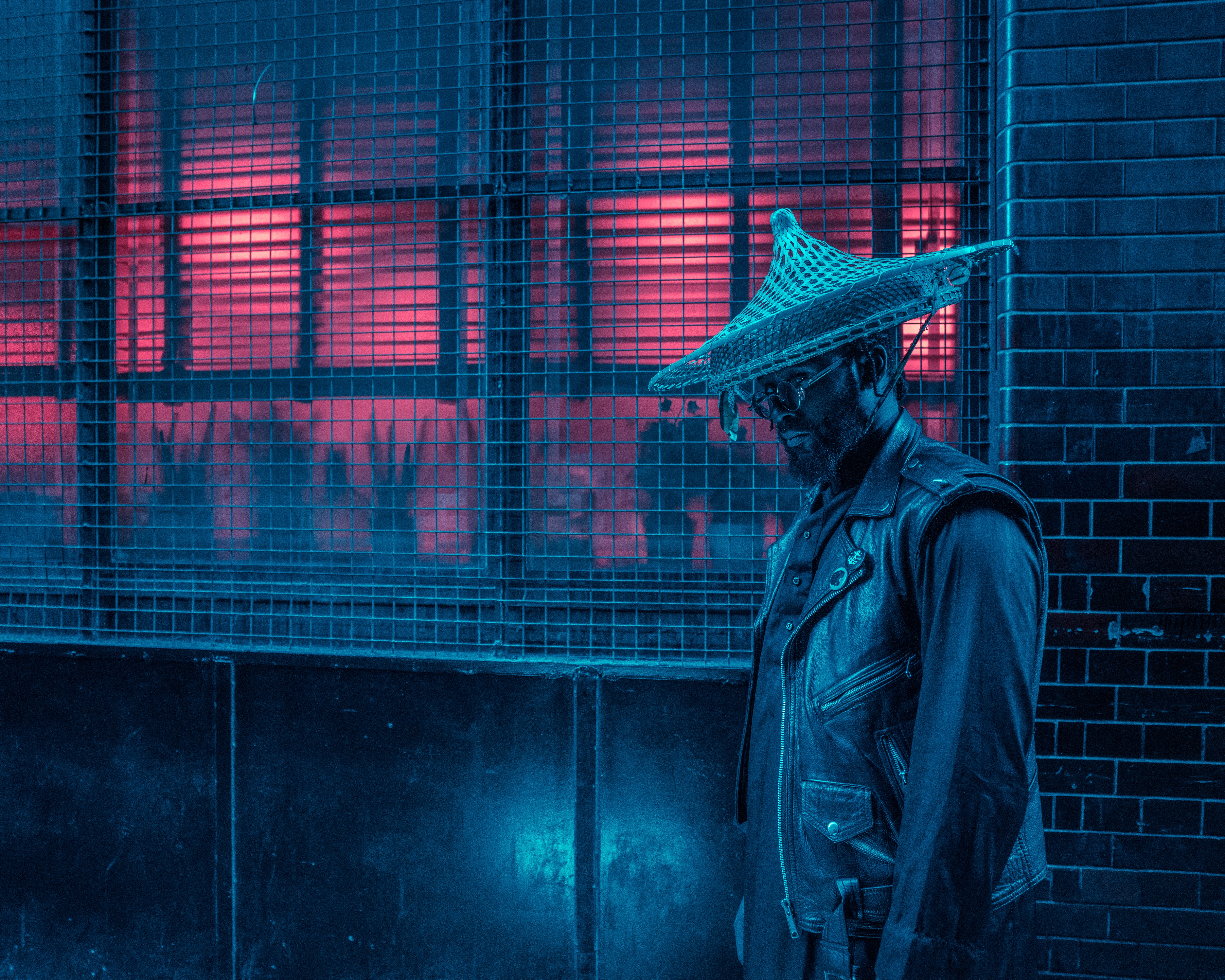 Man in conical hat and leather jacket at night HD Wallpaper