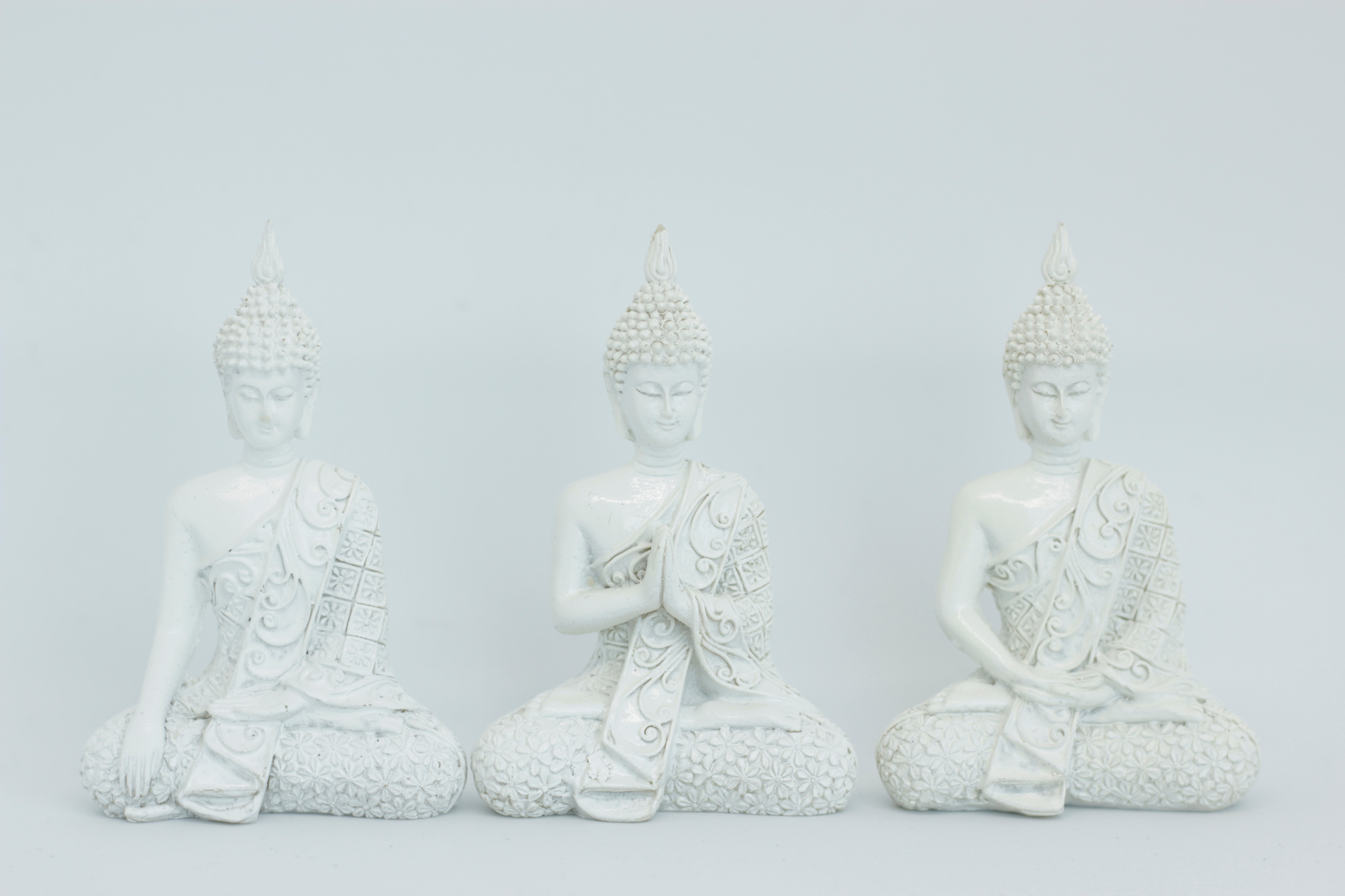 Three white Buddha statues in meditation HD Wallpaper