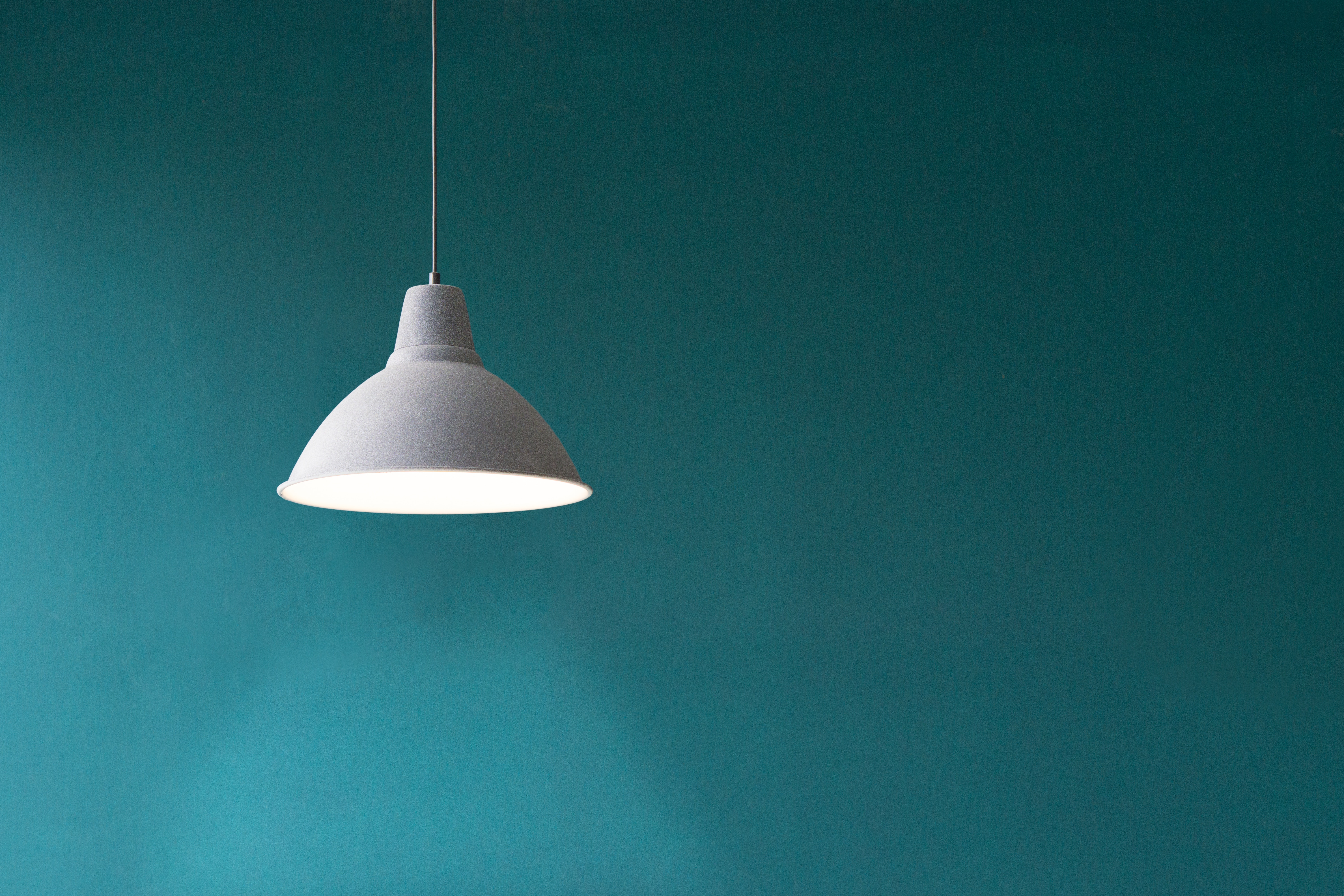 Minimalist grey pendant light against teal wall HD Wallpaper