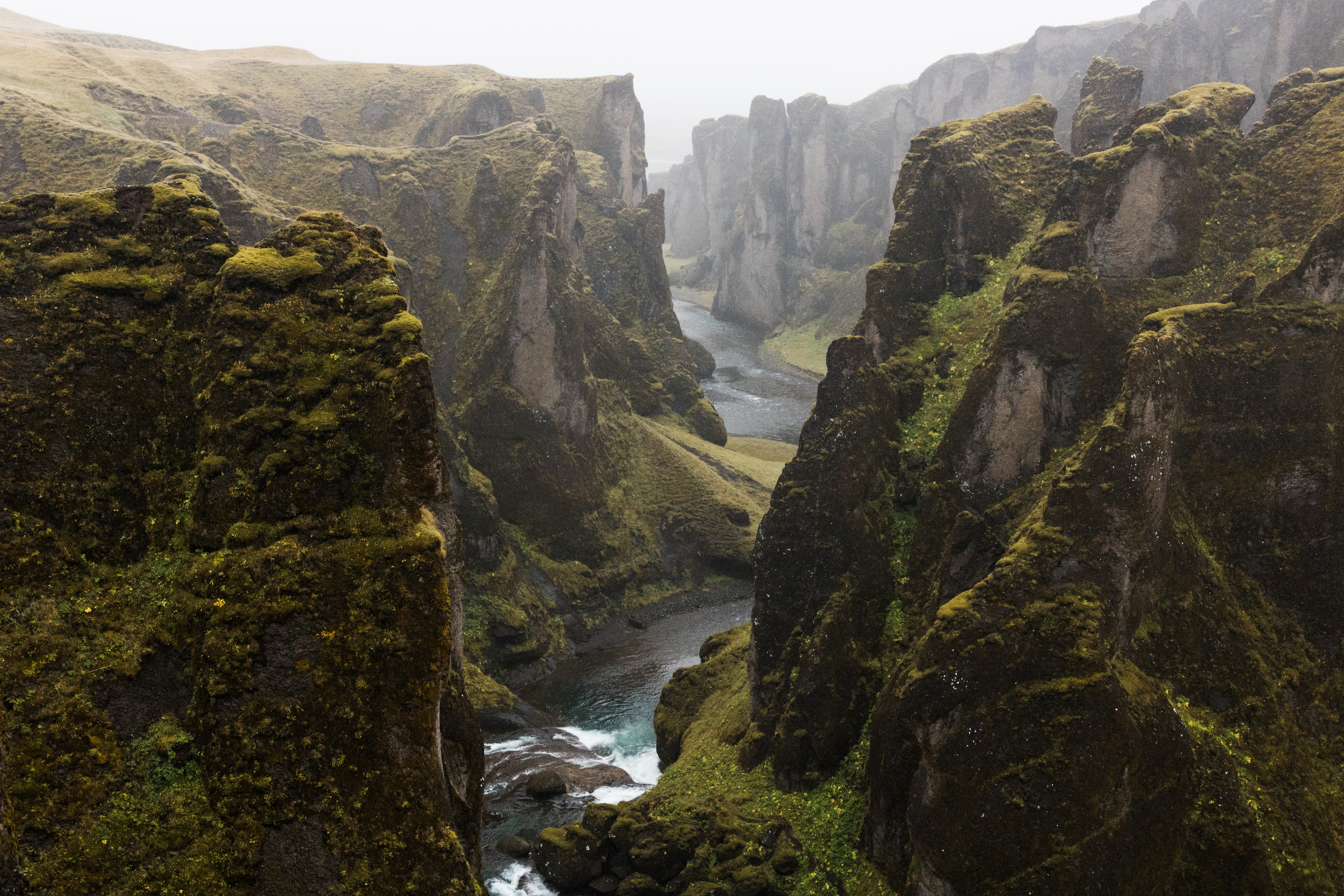 Moss-covered canyon with a river flowing through it HD Wallpaper