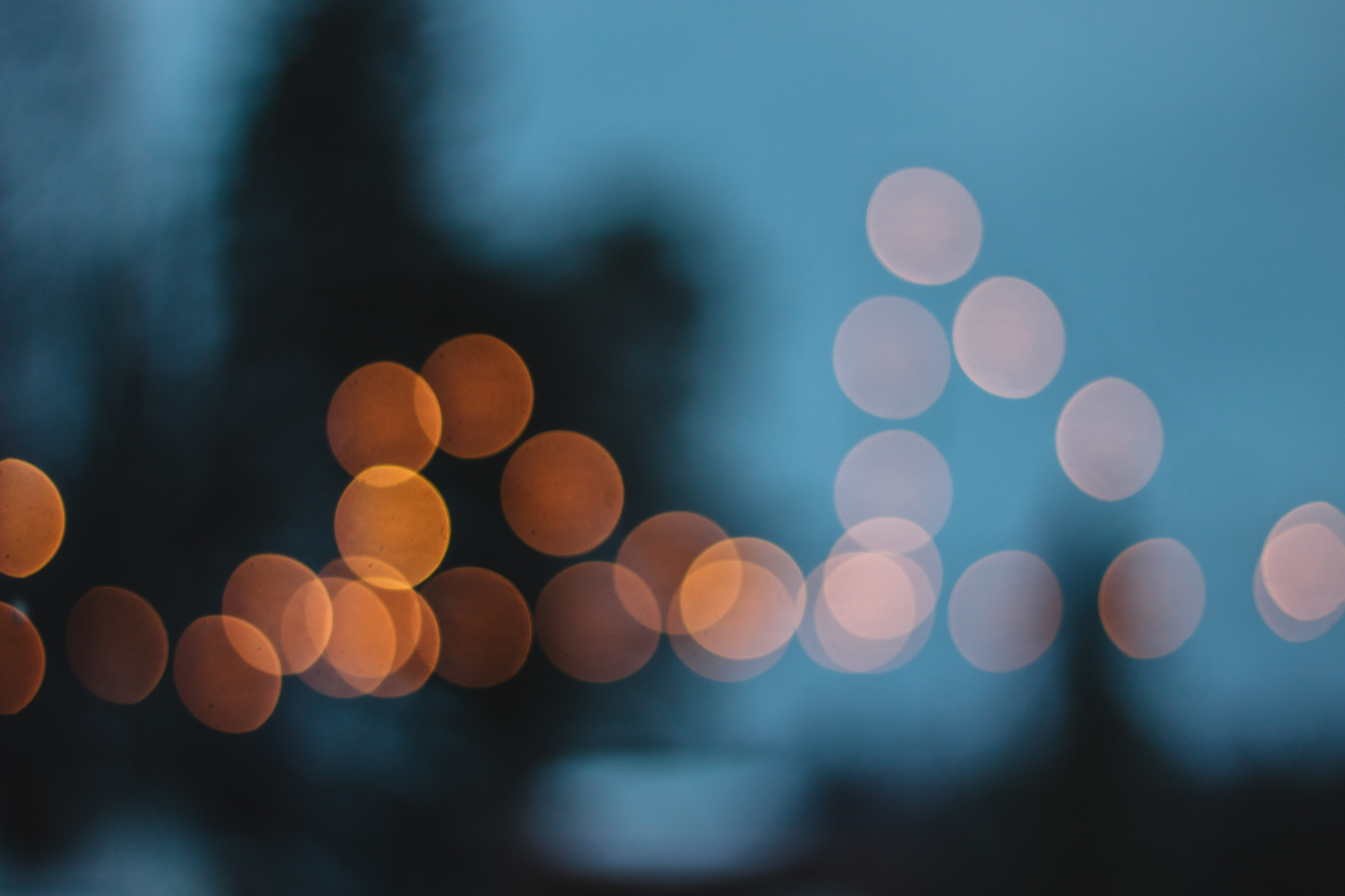 Orange and white bokeh lights against blue background HD Wallpaper