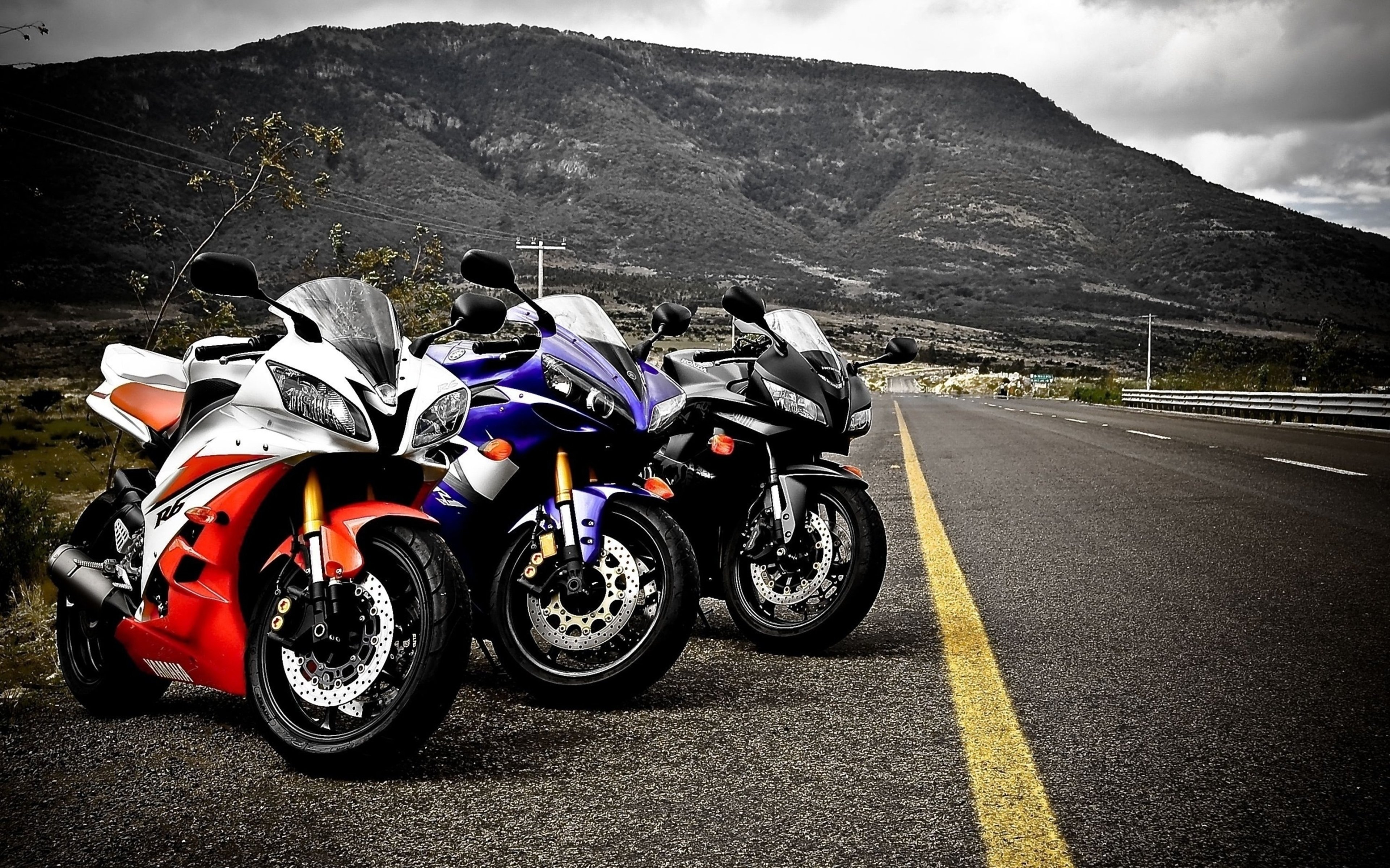 Three sport motorcycles parked on the side of a road HD Wallpaper