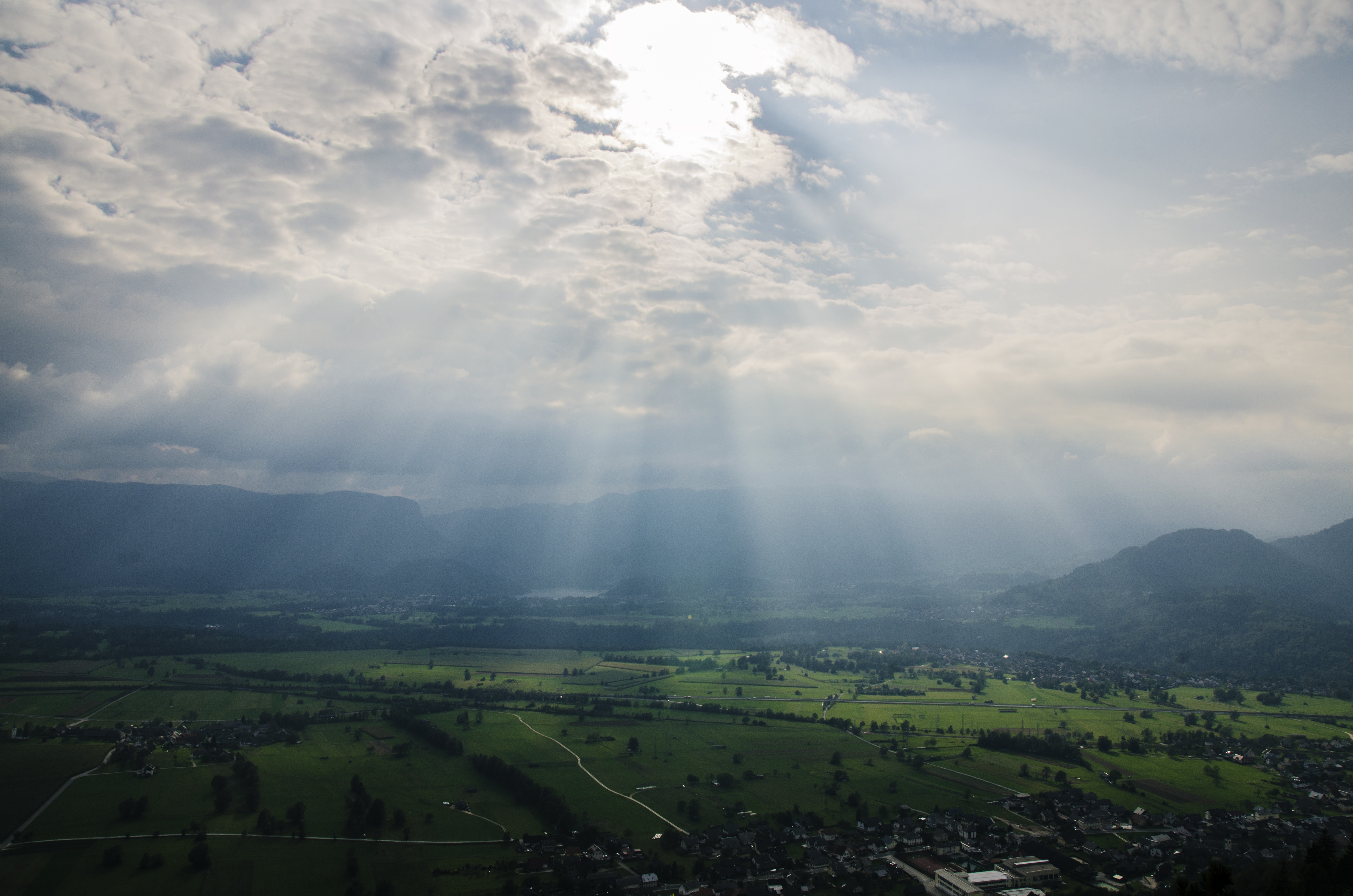 Sunbeams over a green valley and mountains HD Wallpaper