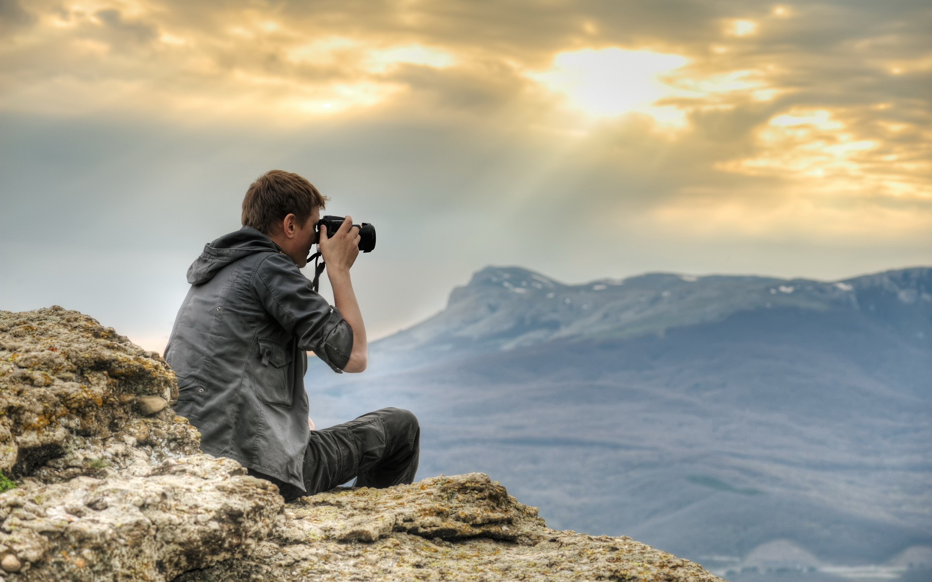 Man with camera on mountain cliff HD Wallpaper