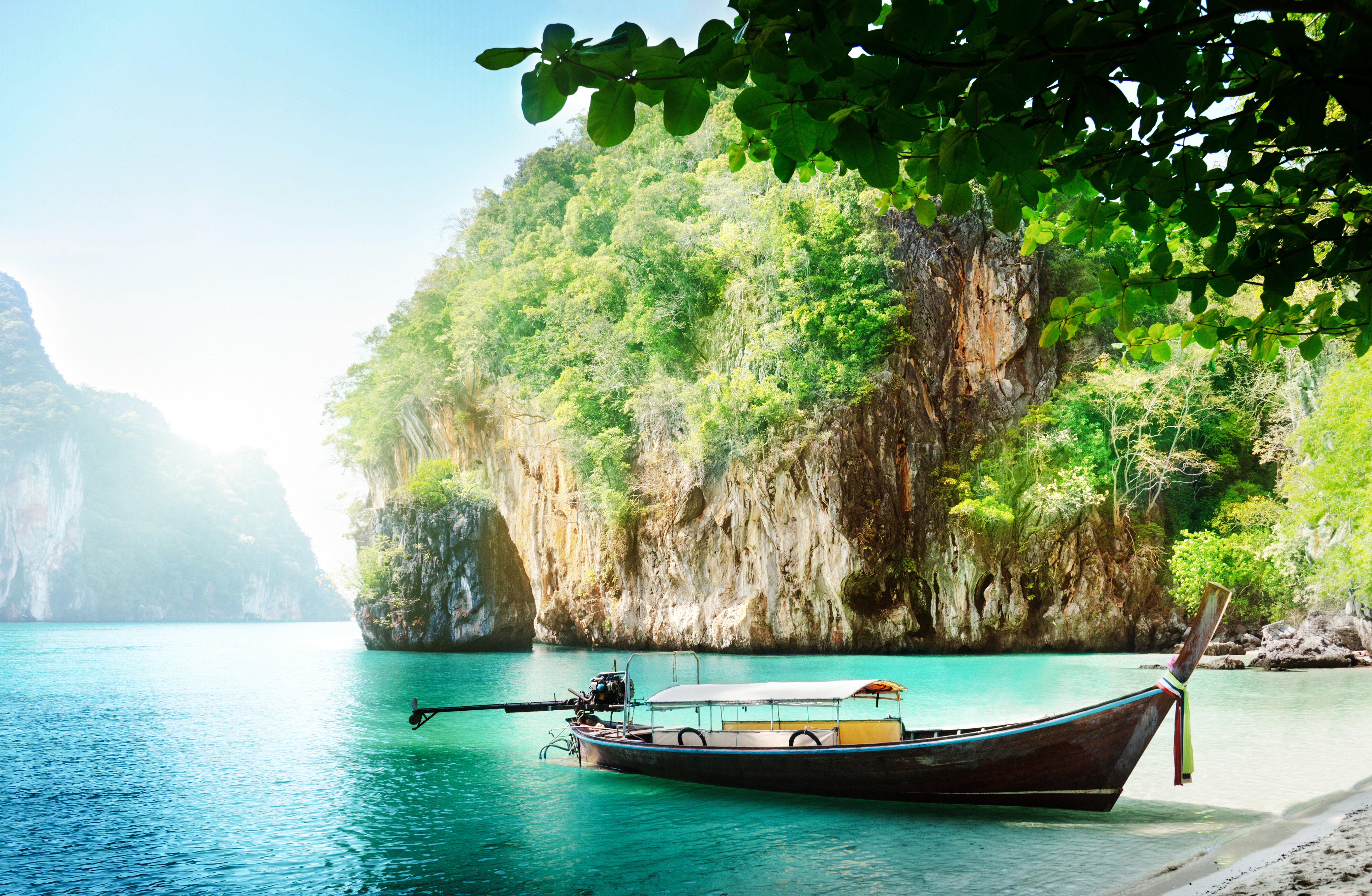 Longtail boat on turquoise water near limestone cliffs in Thailand HD Wallpaper