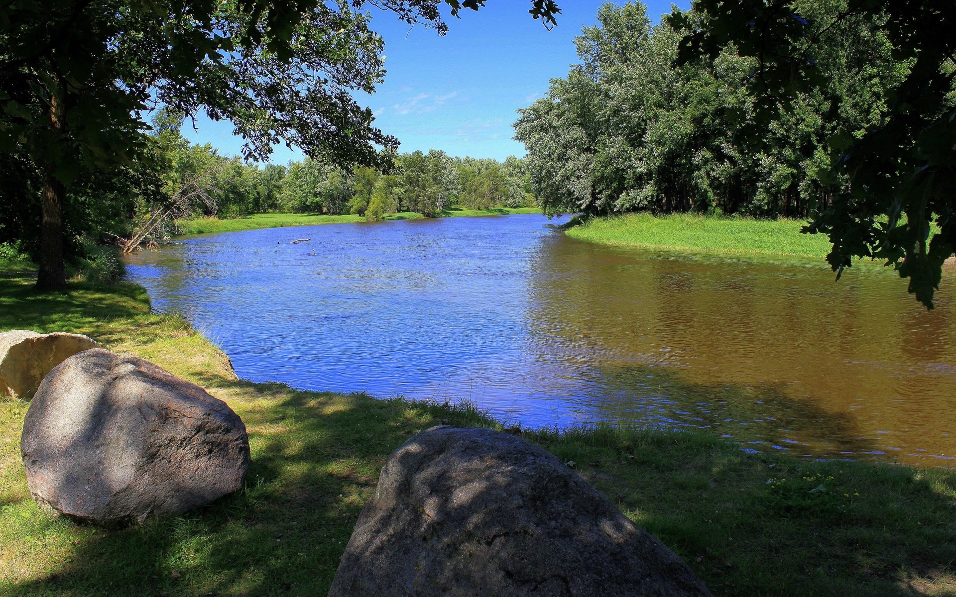 River flowing through a forest with large rocks HD Wallpaper