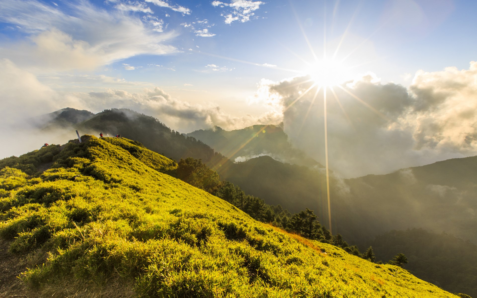 Sunlit mountain ridge with clouds and hikers HD Wallpaper