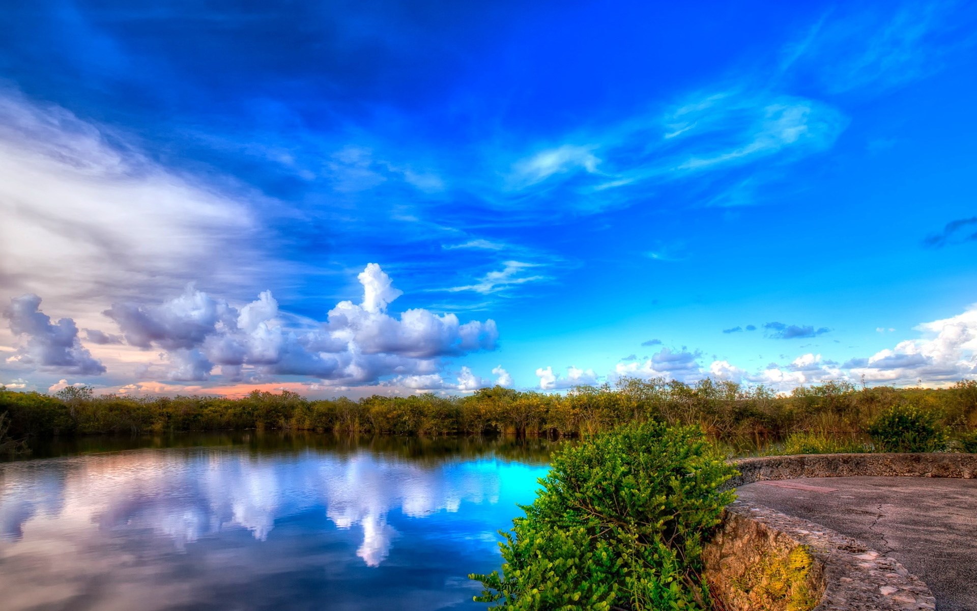 Calm lake reflecting a bright blue sky with clouds HD Wallpaper