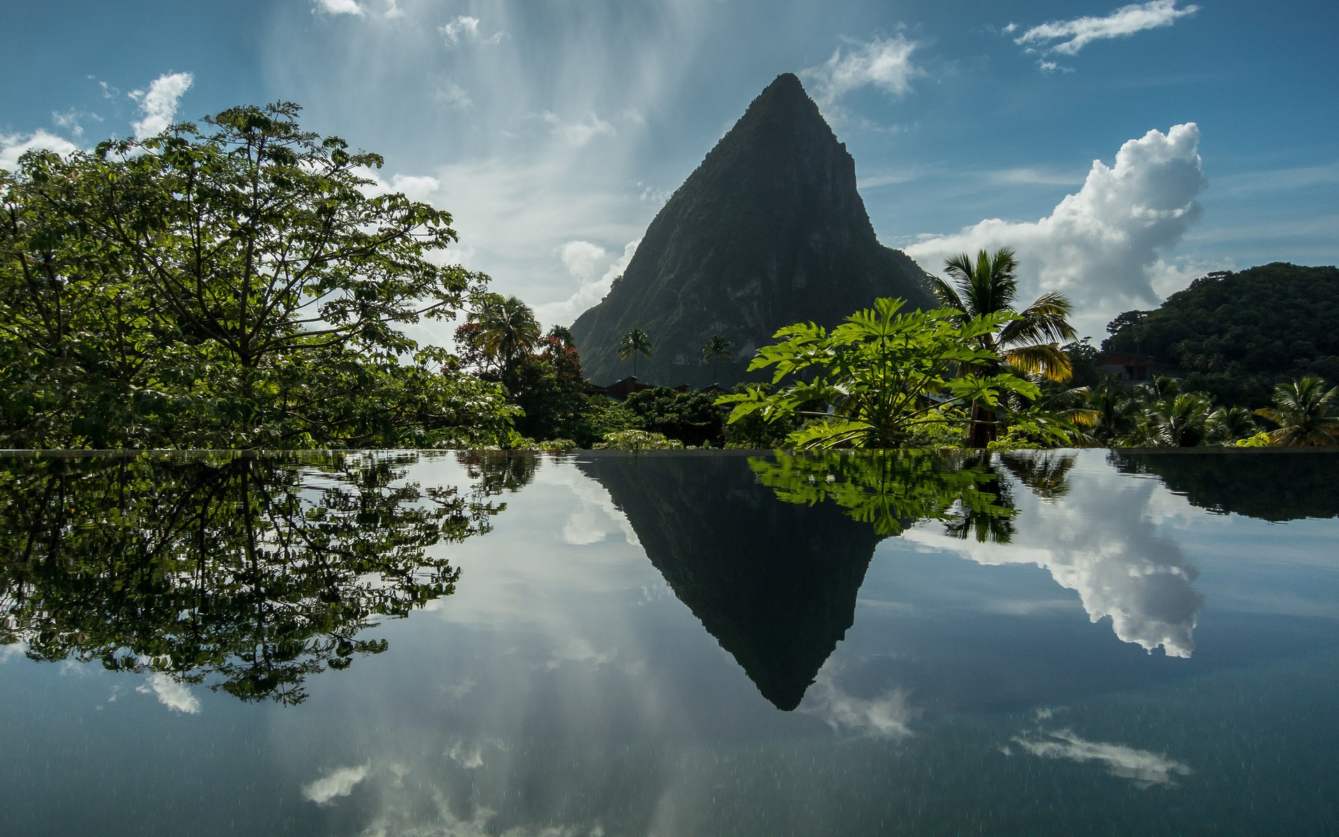 Reflection of Pitons and tropical foliage in infinity pool HD Wallpaper