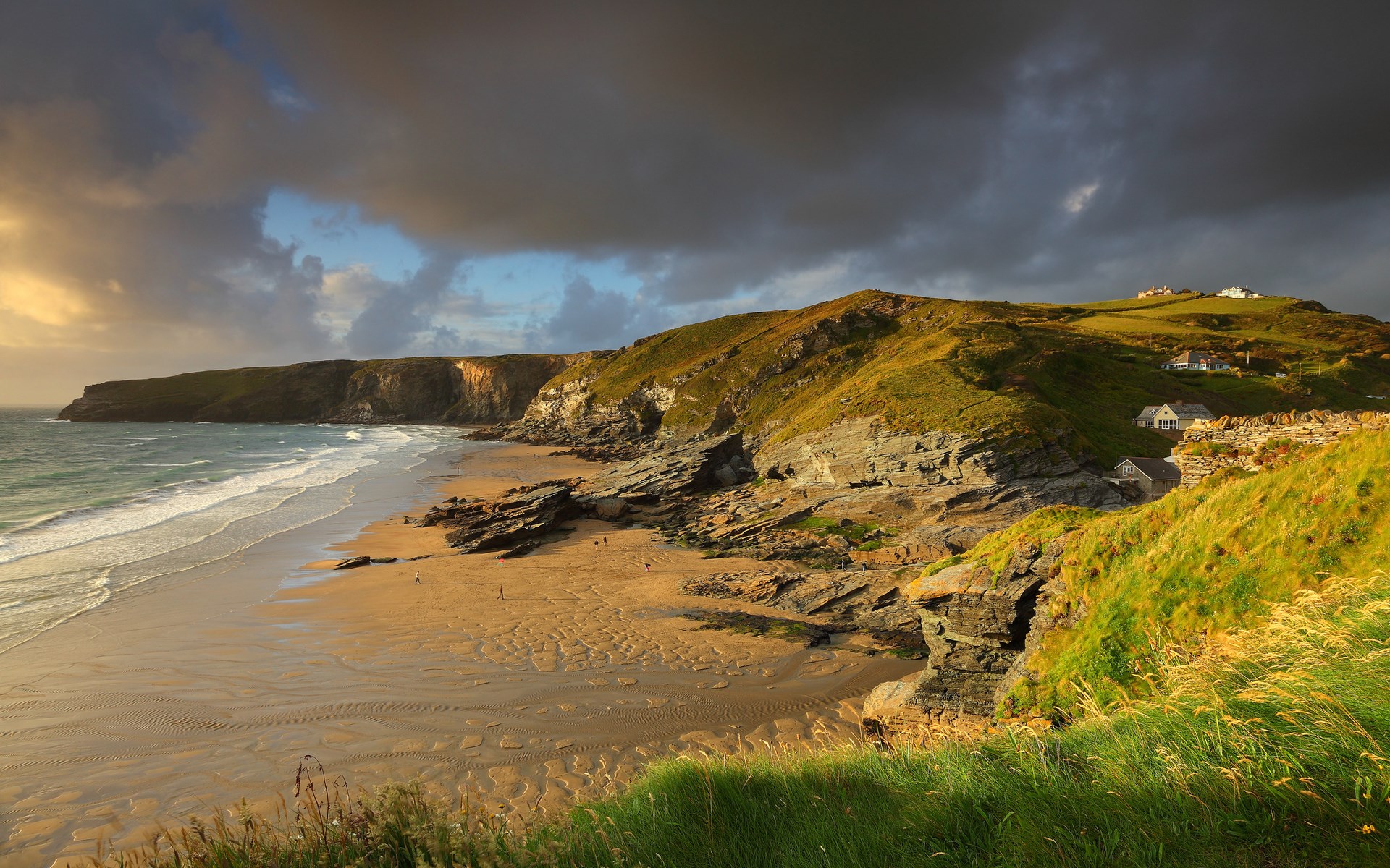Coastal cliffs and beach with houses on the hill HD Wallpaper