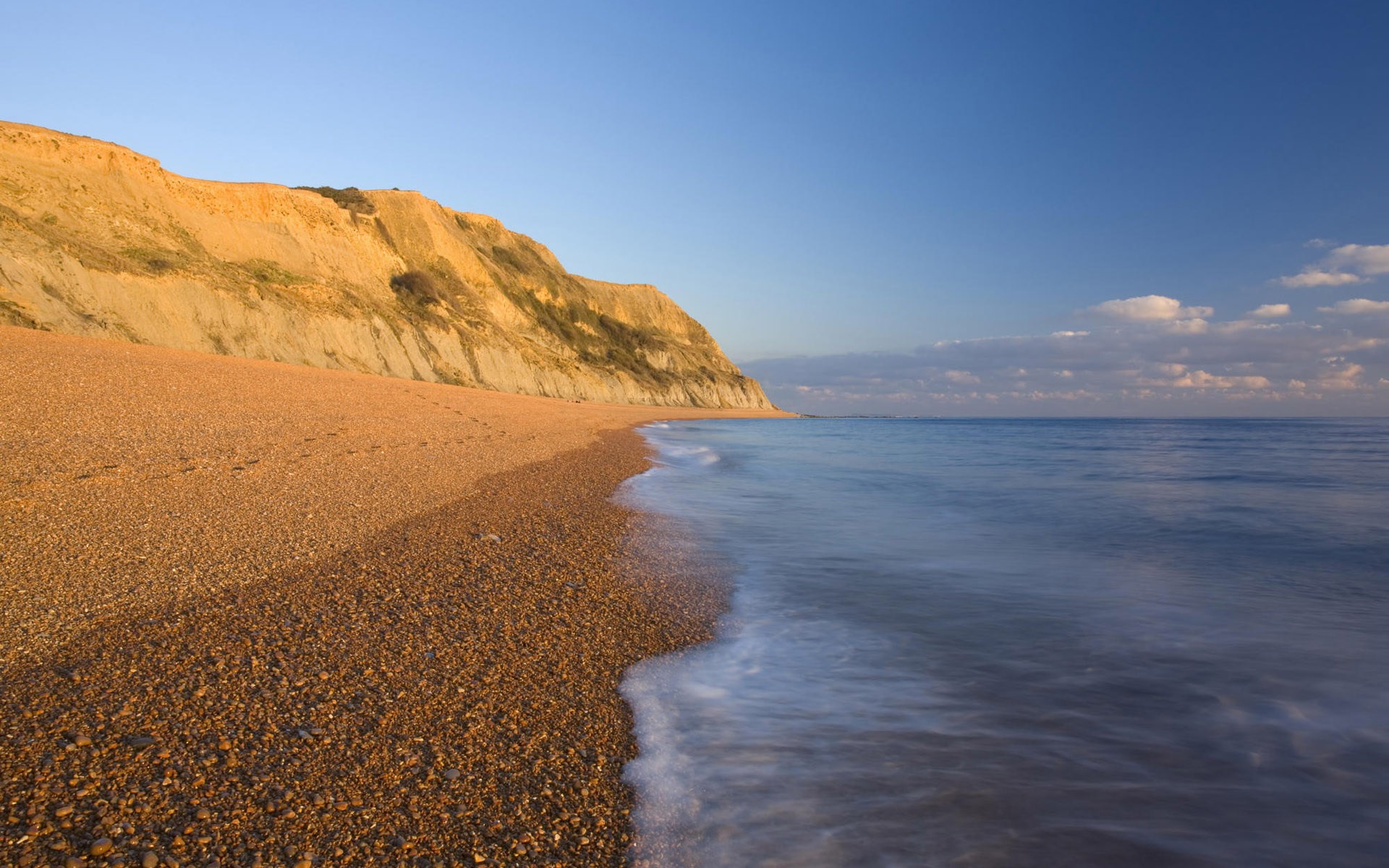 Pebble beach with cliff and ocean HD Wallpaper