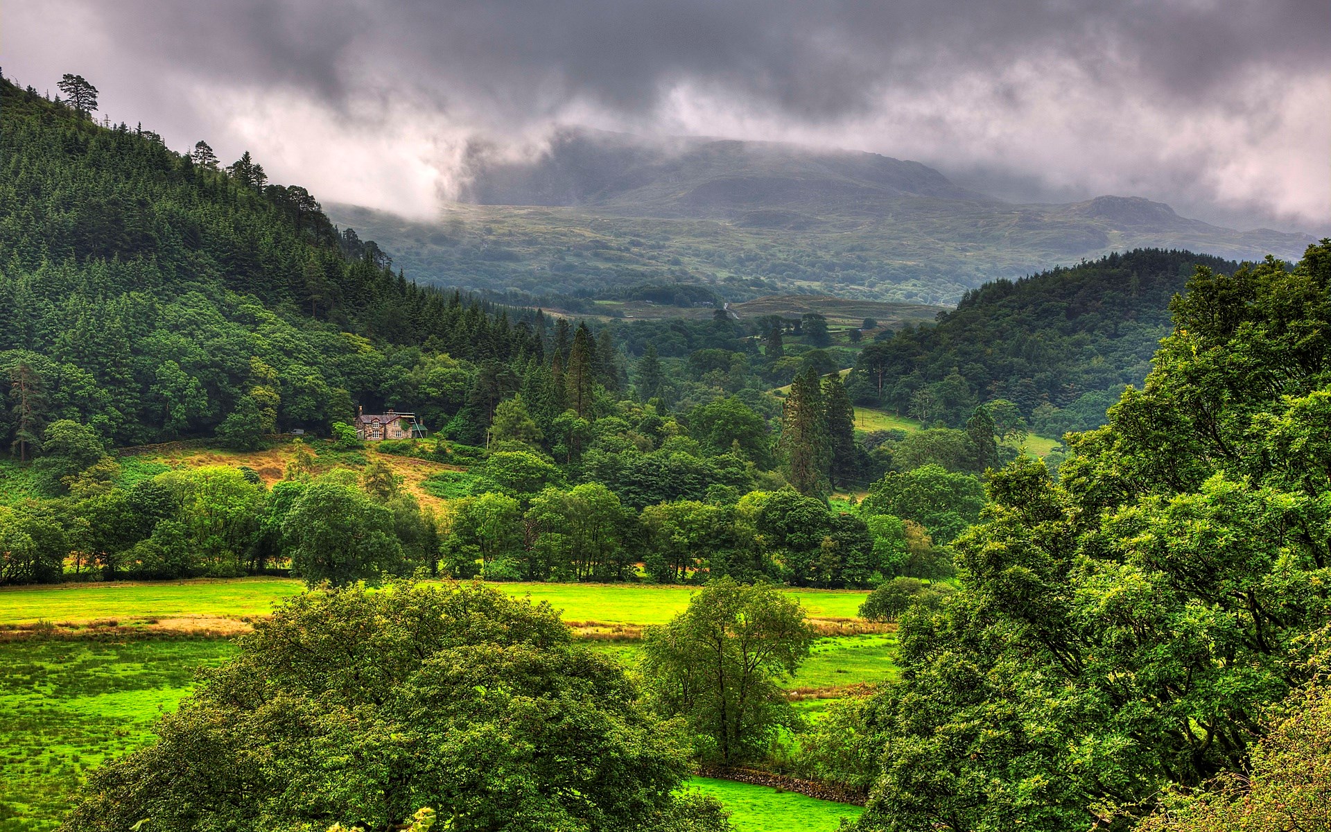 A stone house sits on a hill in a green valley HD Wallpaper
