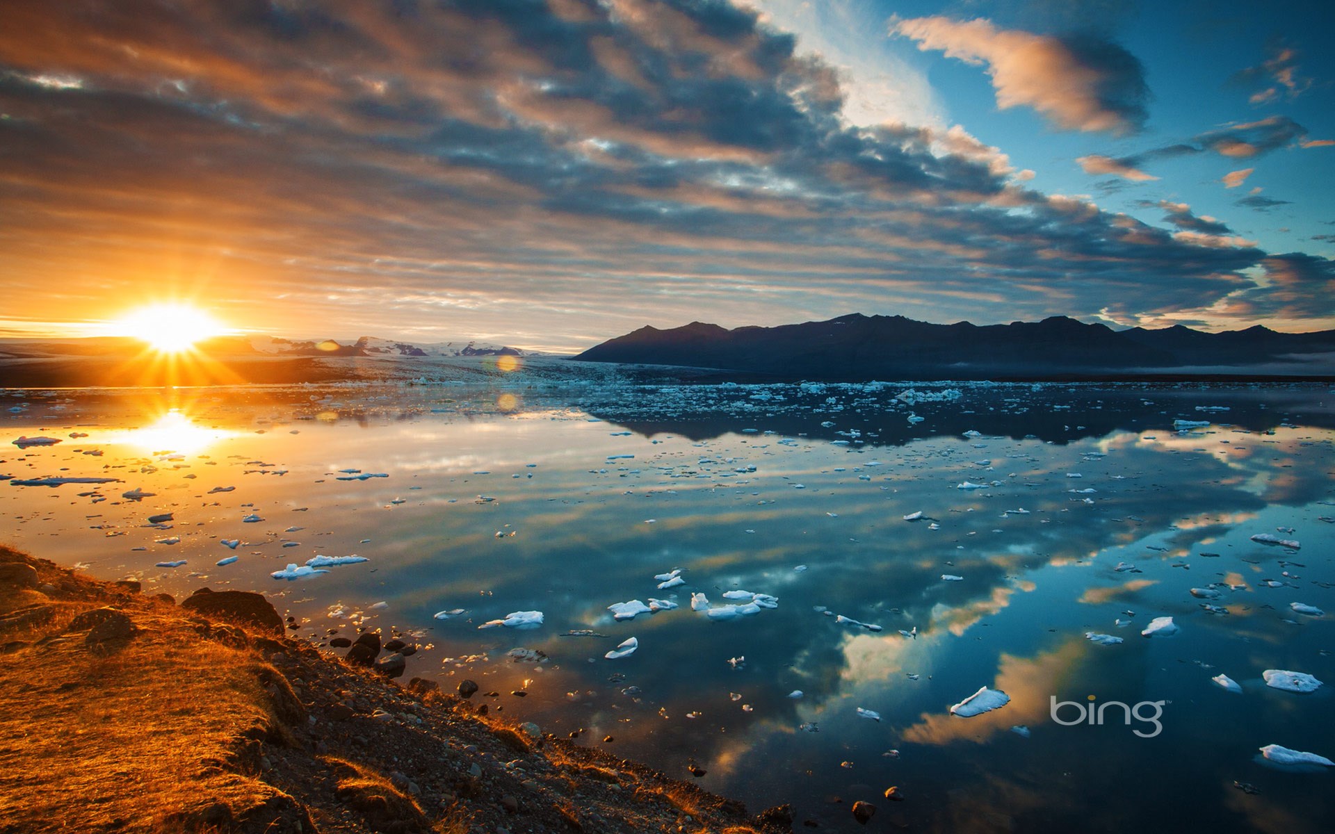 Sunset over glacial lagoon with icebergs and mountains HD Wallpaper
