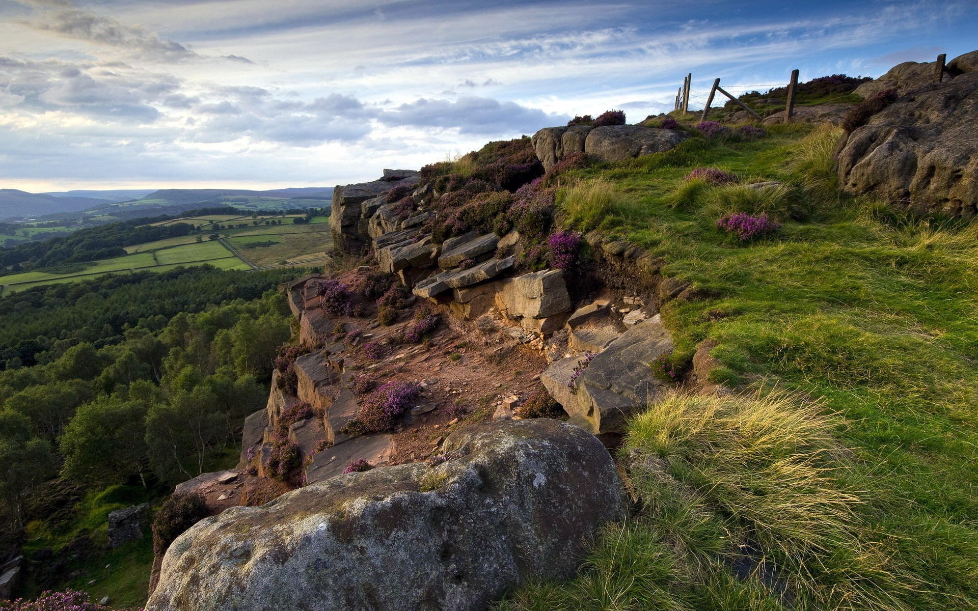 Rocky cliff overlooking a green valley and forest HD Wallpaper