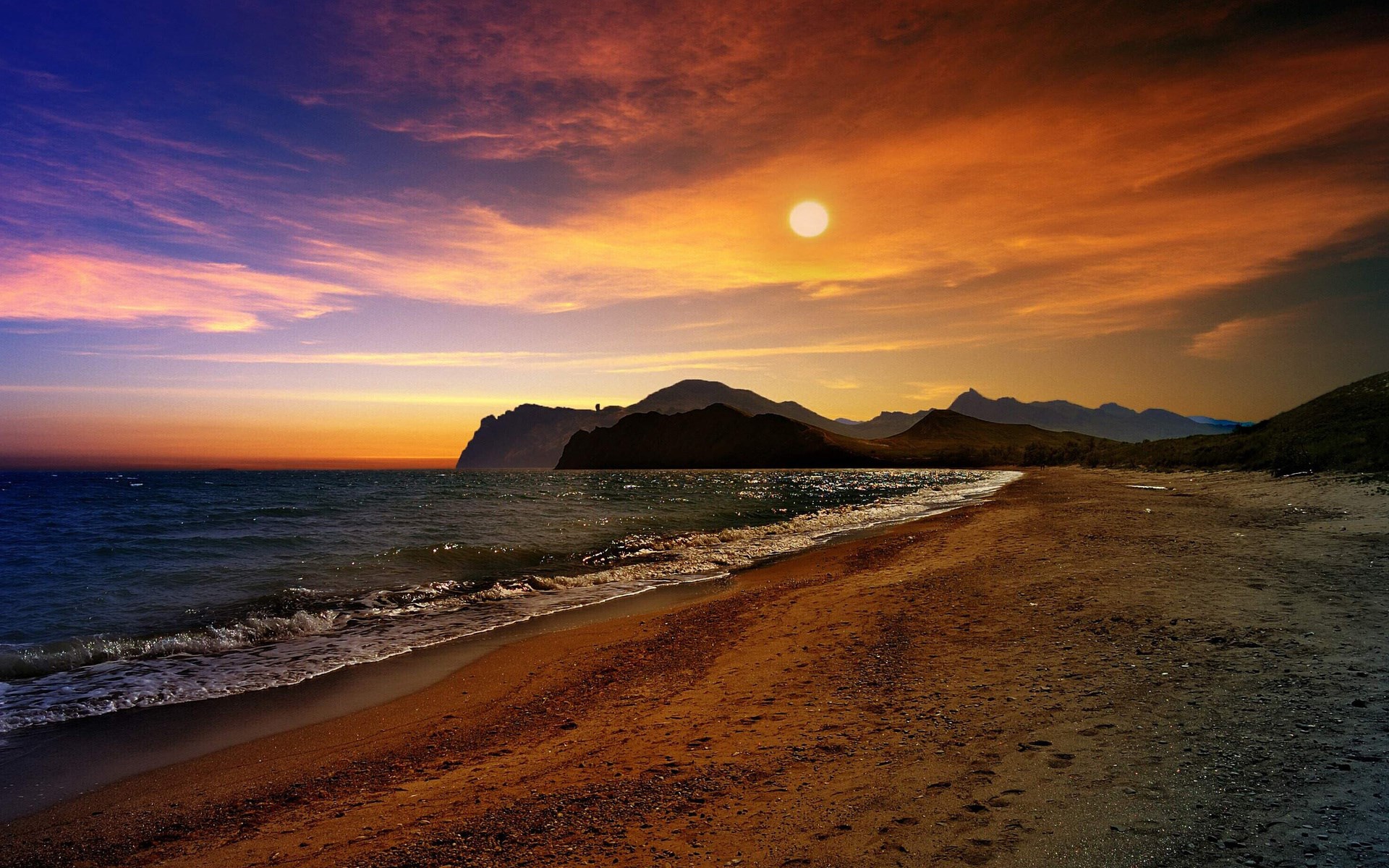 Sunset over a beach with mountains and ocean HD Wallpaper