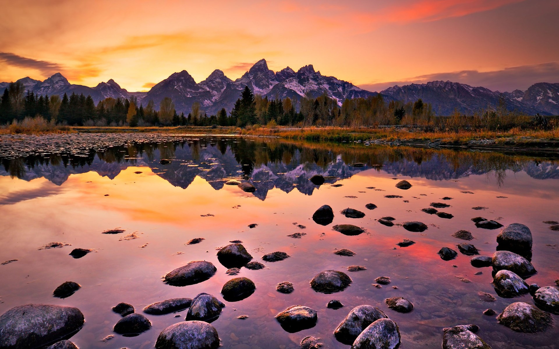 Mountains reflected in a lake at sunset HD Wallpaper