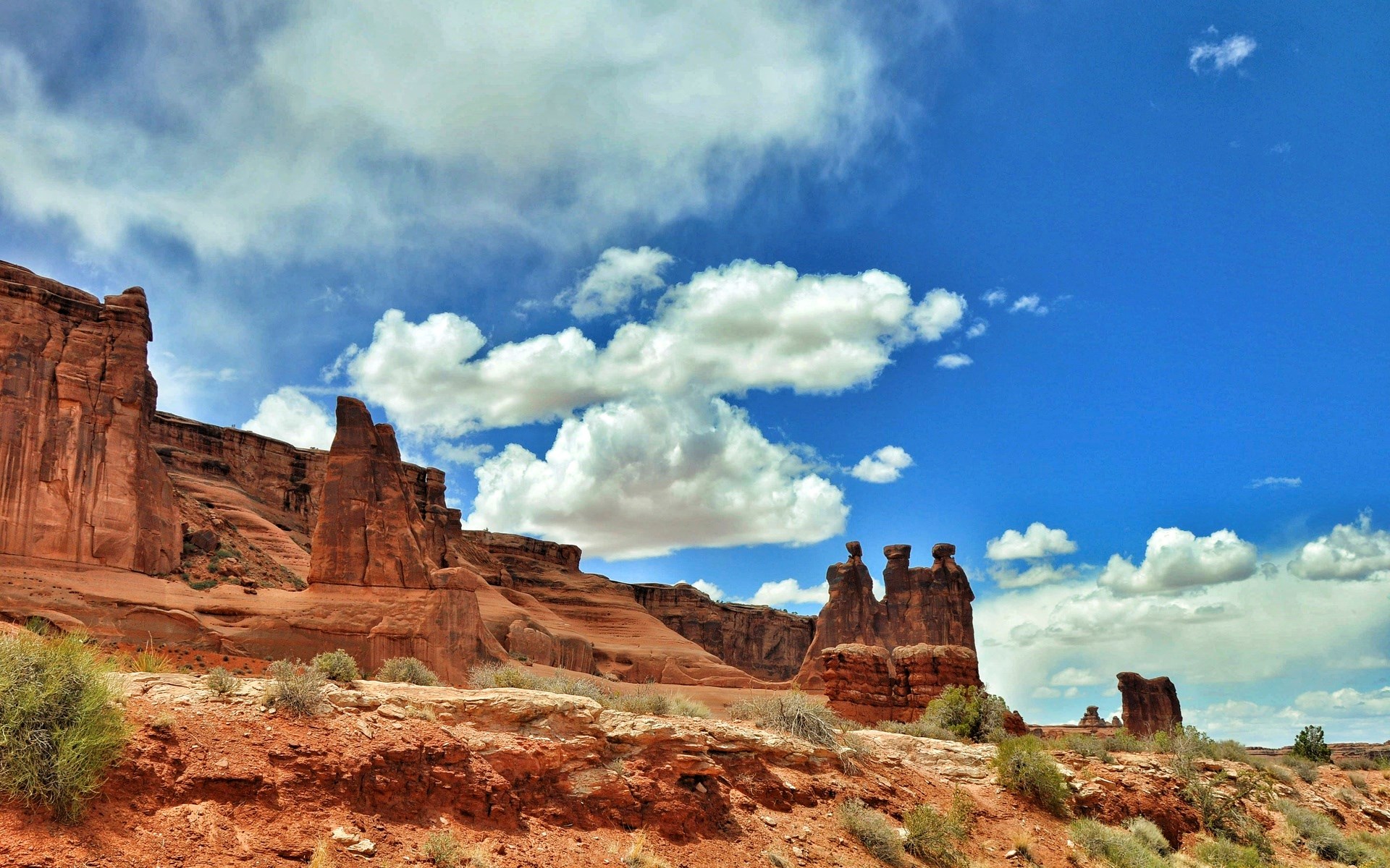 Red rock formations under a blue sky with clouds HD Wallpaper
