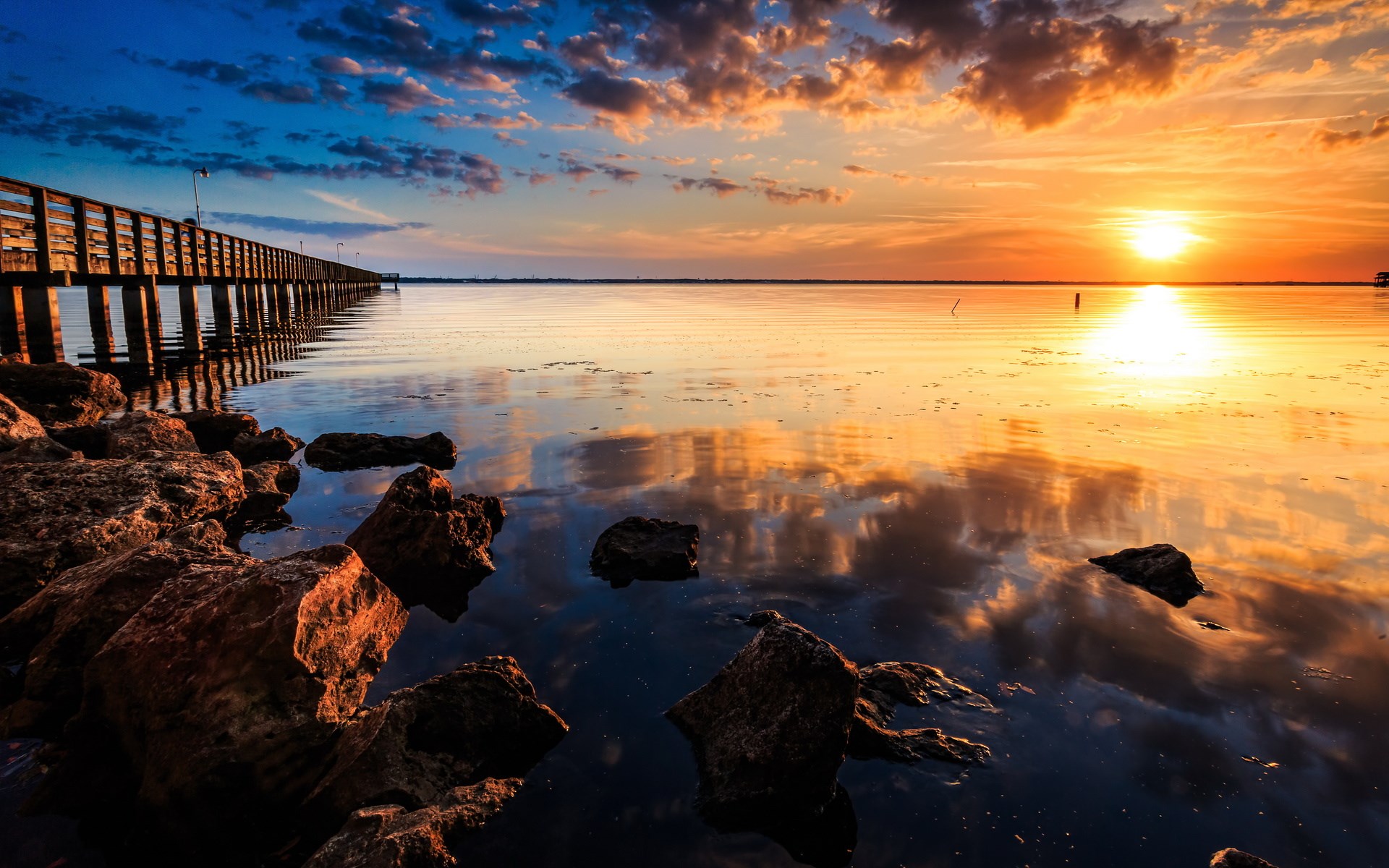 Pier over calm water at sunset HD Wallpaper