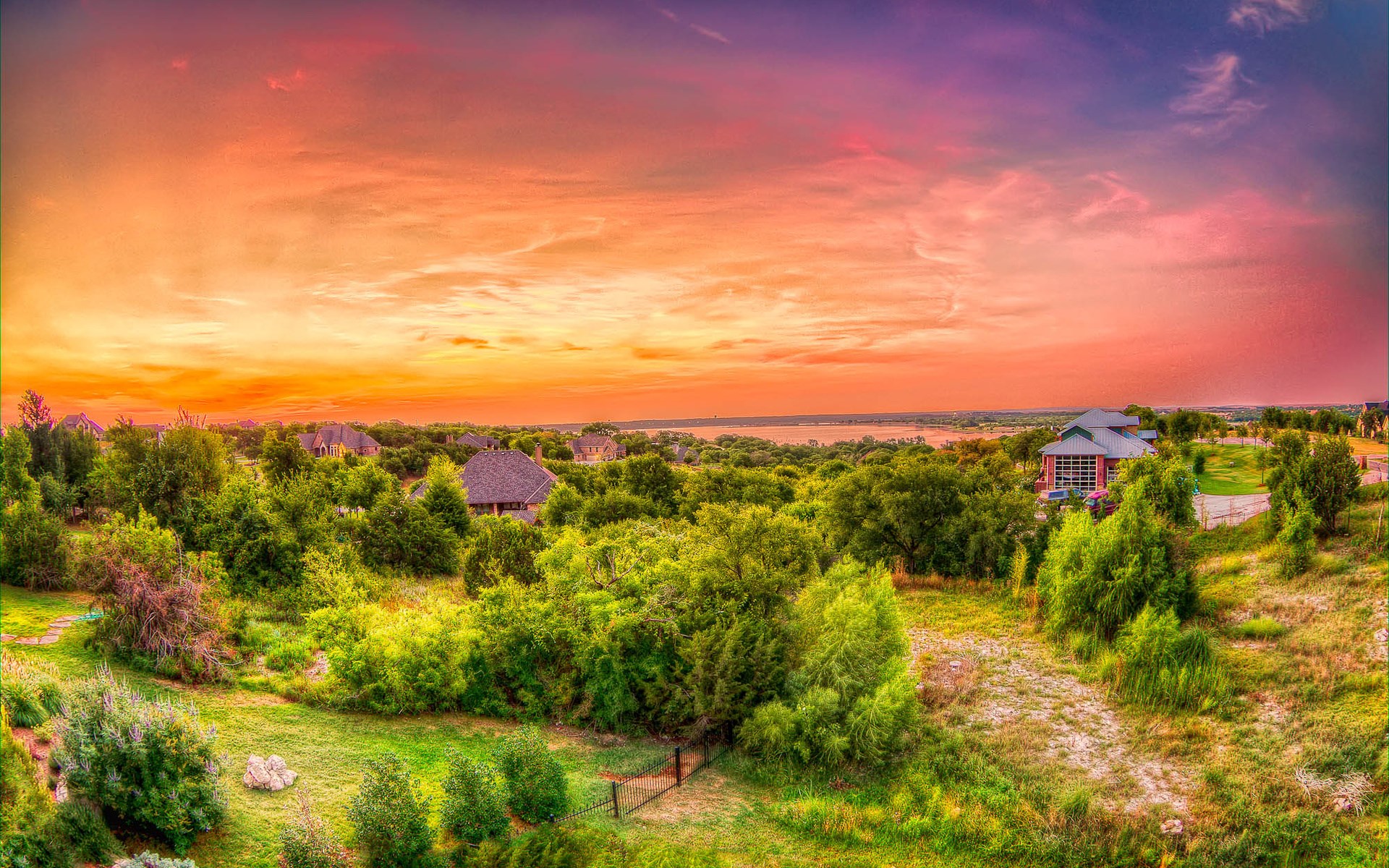 Sunset over a suburban landscape with houses and trees HD Wallpaper