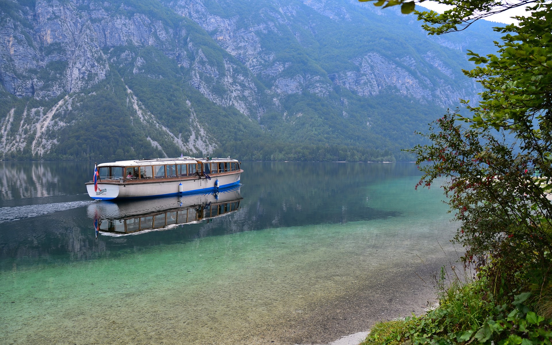 Boat on a clear lake with mountains HD Wallpaper