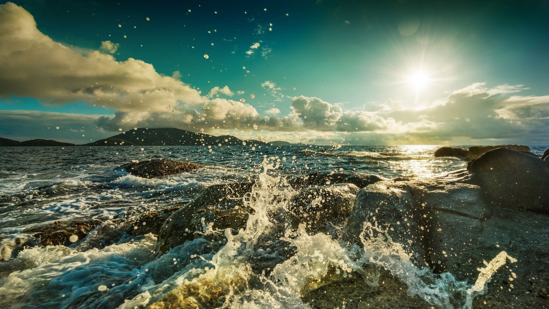 Waves crashing on rocks with sun and clouds HD Wallpaper