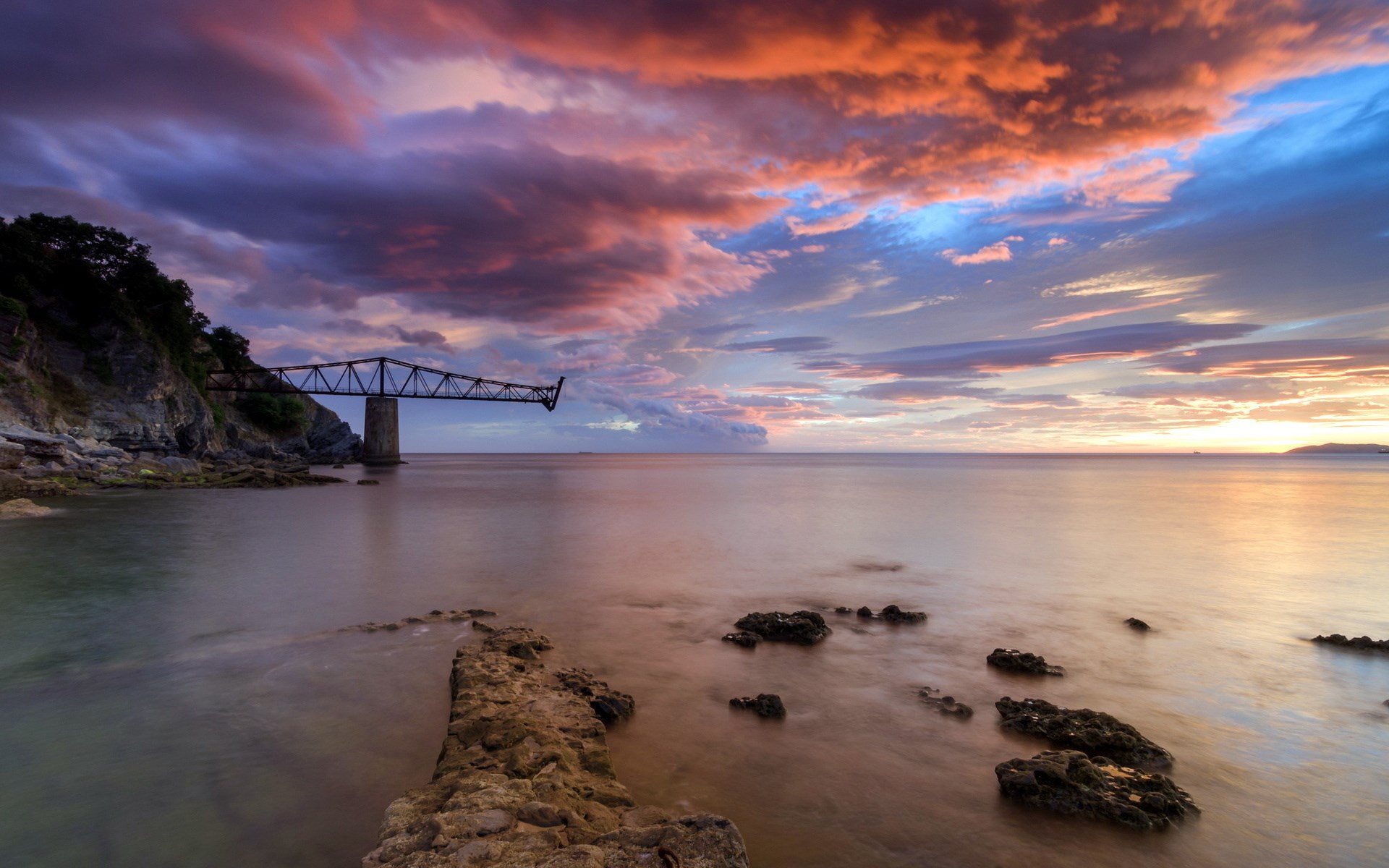Bridge extending over the sea at sunset HD Wallpaper