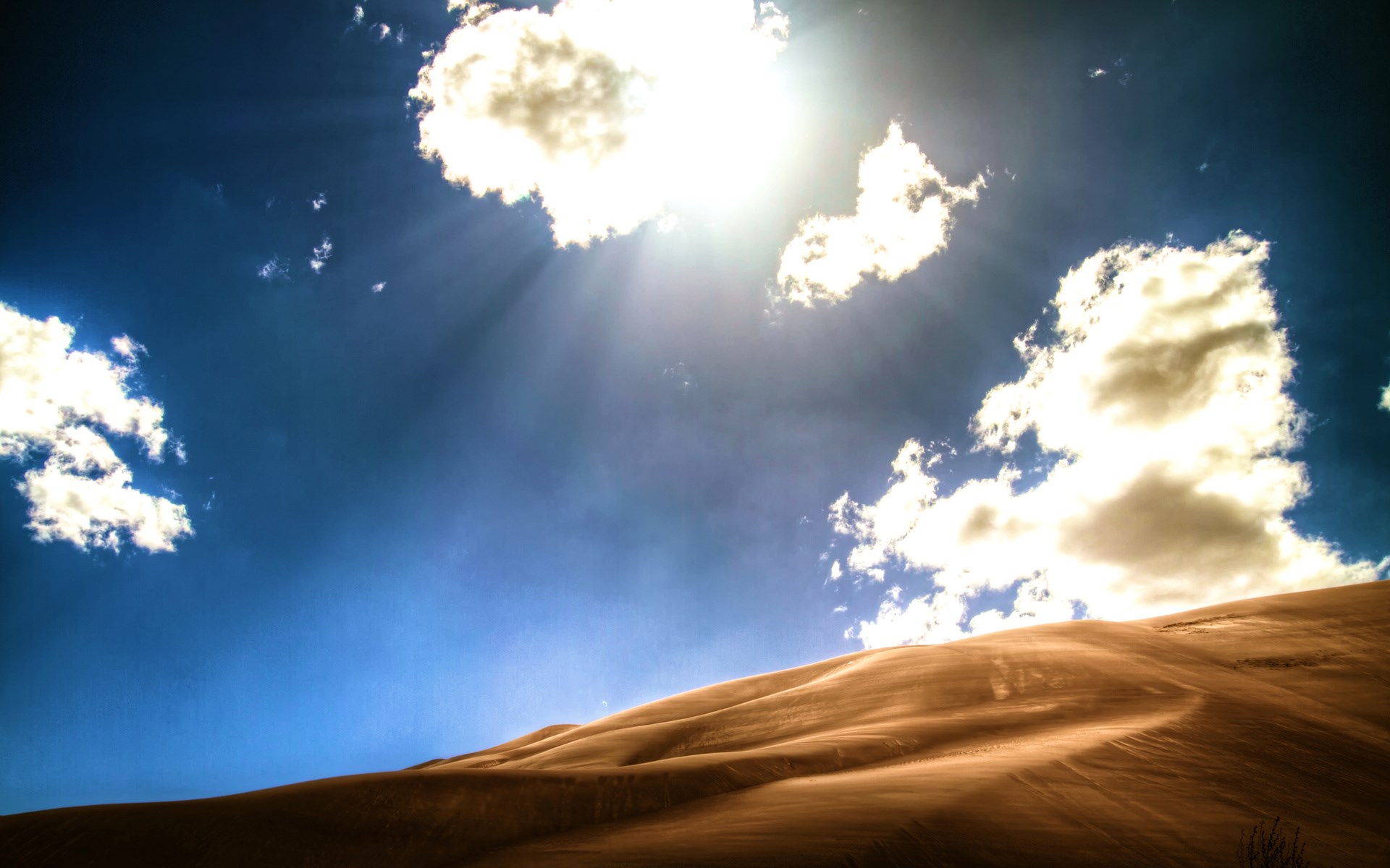 Sunlight beams through clouds over sand dunes HD Wallpaper
