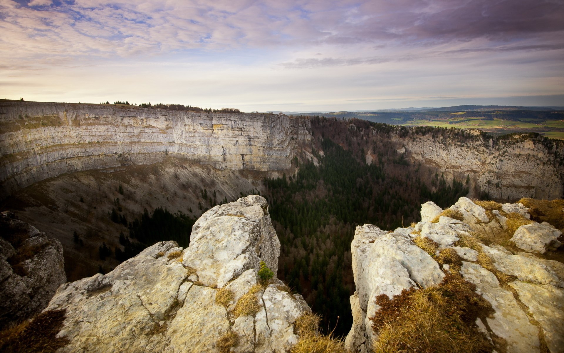 Crevice in a rocky cliff overlooking a forest HD Wallpaper