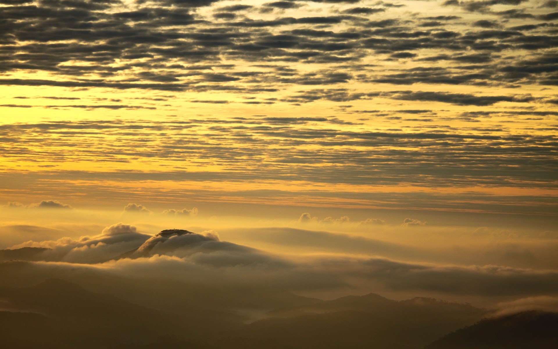 Sunrise over misty mountains with layered clouds HD Wallpaper