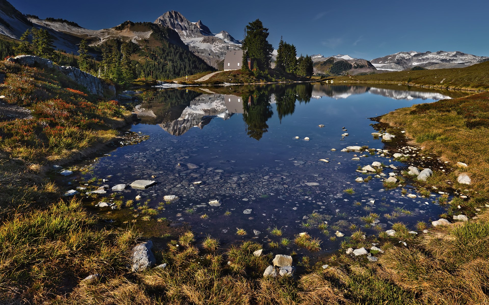 Mountain lake with reflection of peaks and building HD Wallpaper