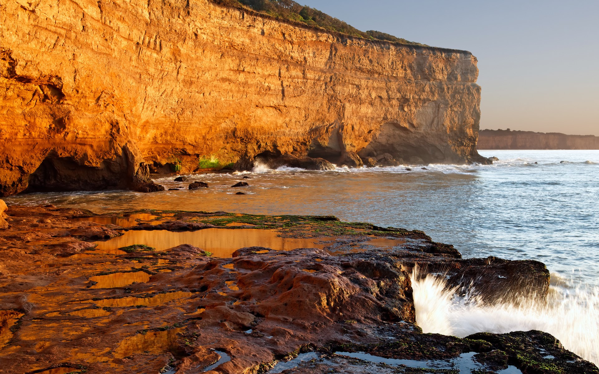 Golden cliffs and ocean waves at sunset HD Wallpaper