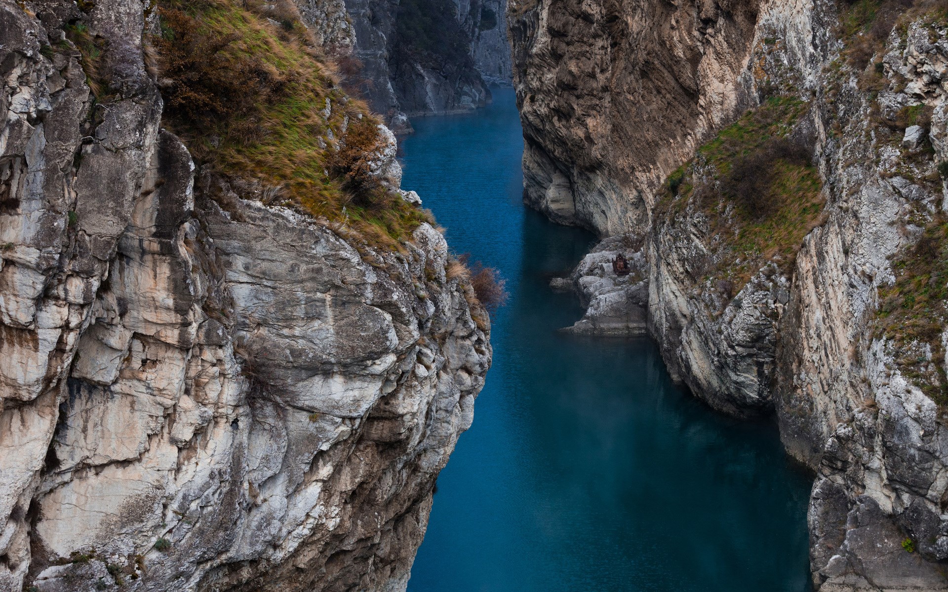 Deep blue river flowing through a rocky canyon HD Wallpaper