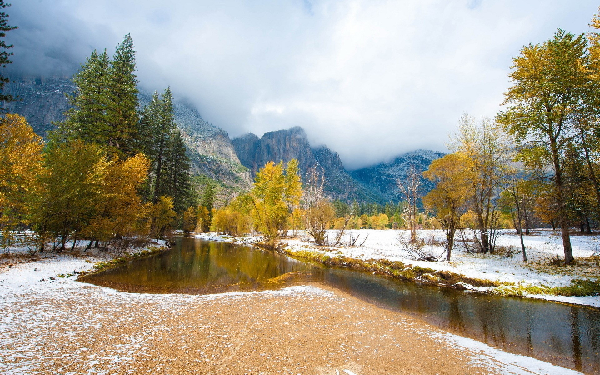 River flowing through a snowy forest with mountains HD Wallpaper