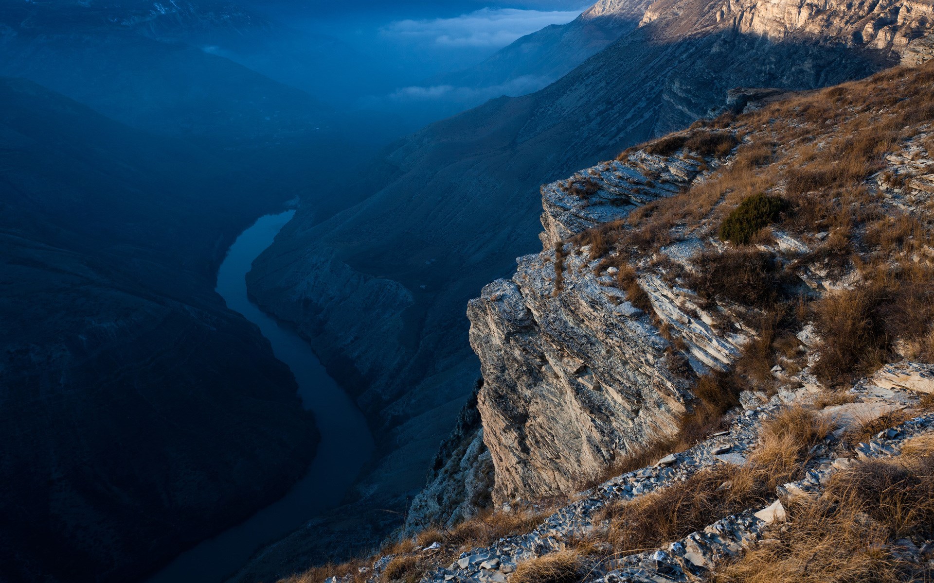 Deep canyon with a winding river and rocky cliffs HD Wallpaper