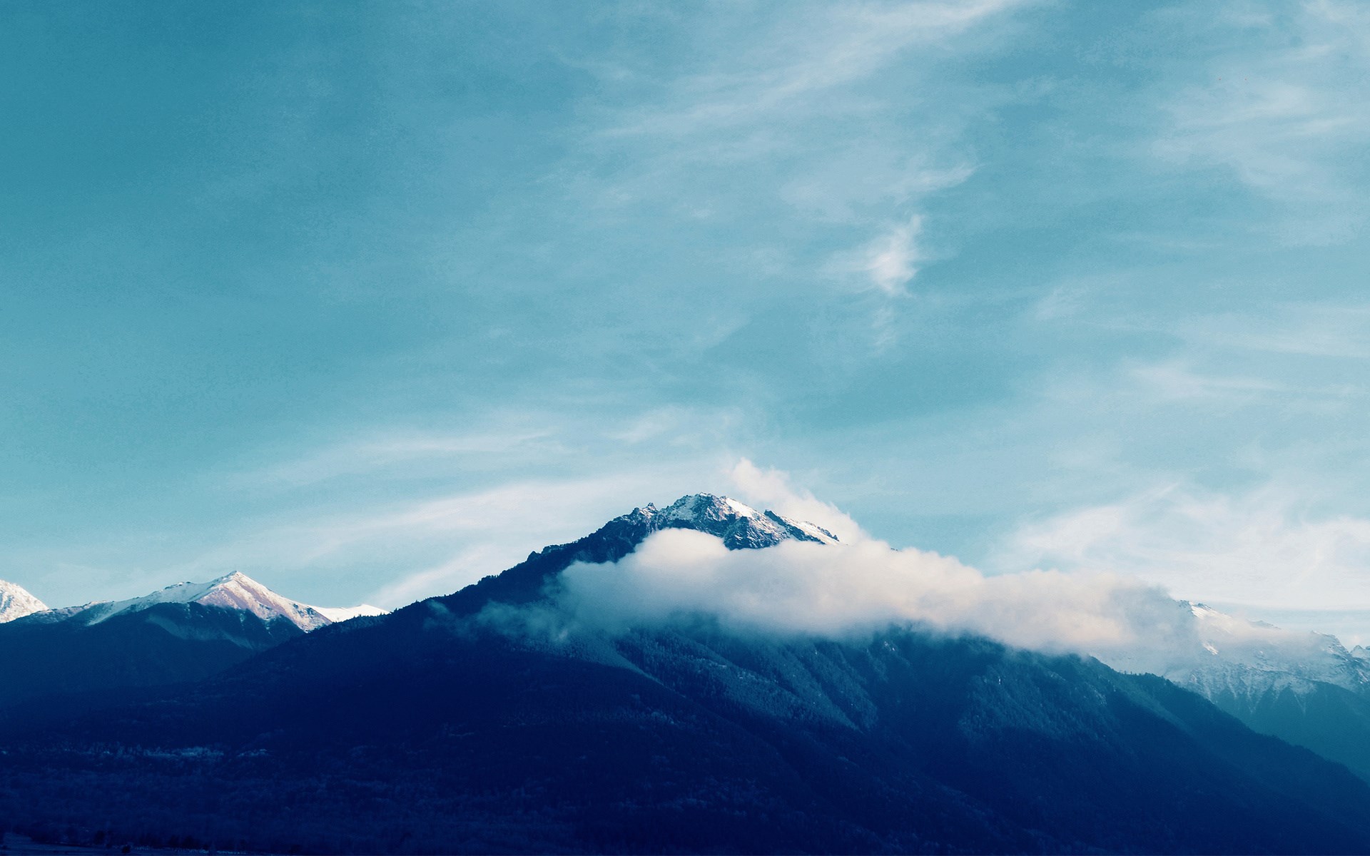 Snow-capped mountains under a cloudy sky HD Wallpaper