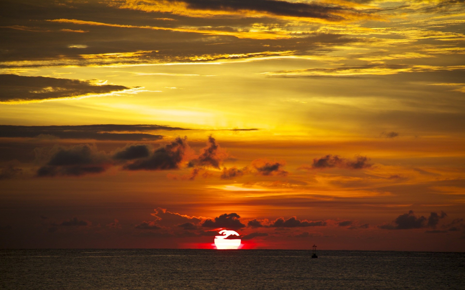 Sunset over the ocean with clouds and a buoy HD Wallpaper