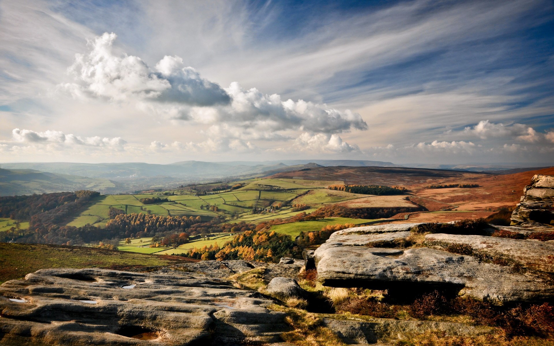 Rocky outcrop overlooking rolling hills and valleys HD Wallpaper