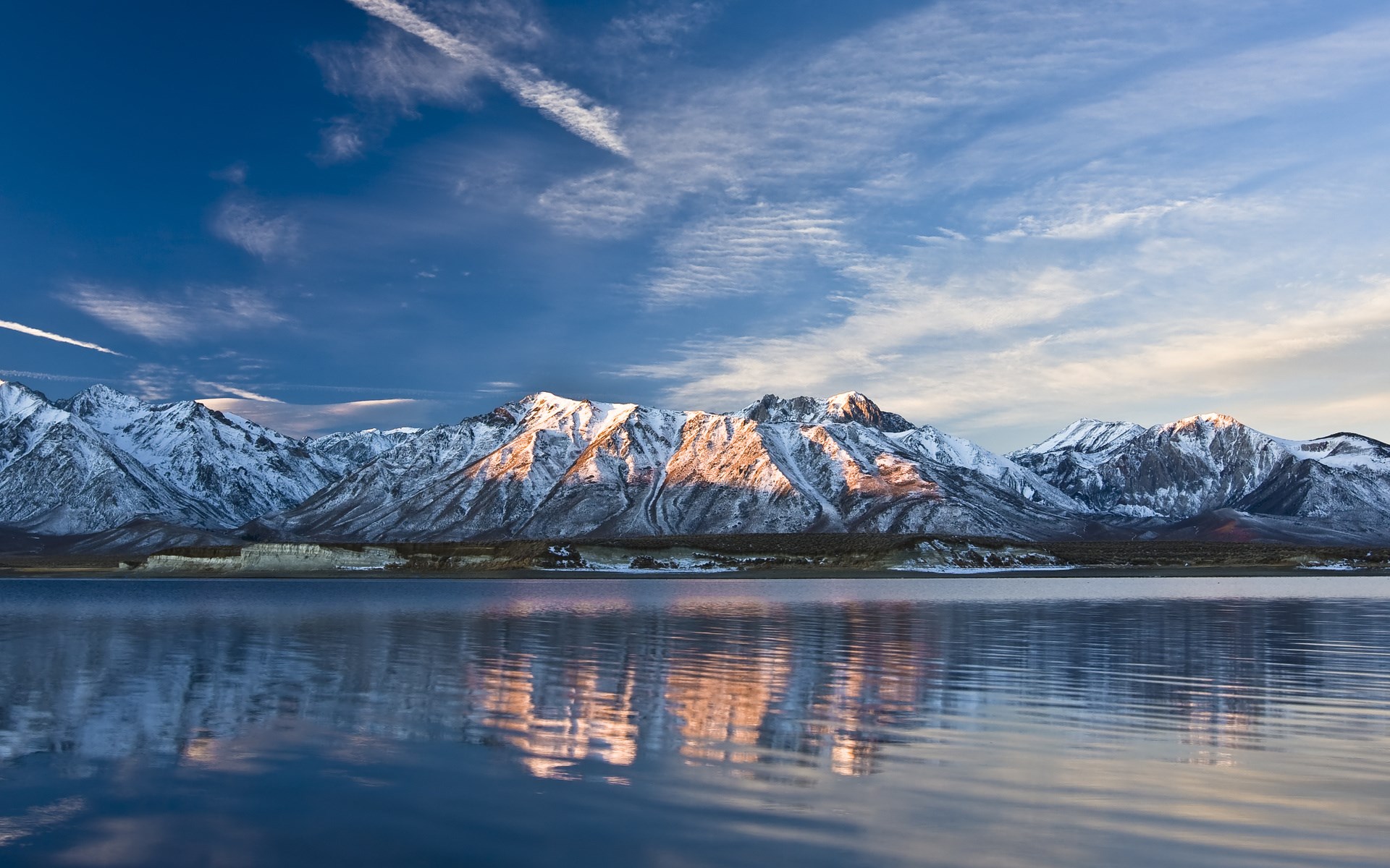 Snow-capped mountains reflected in a lake under a blue sky HD Wallpaper