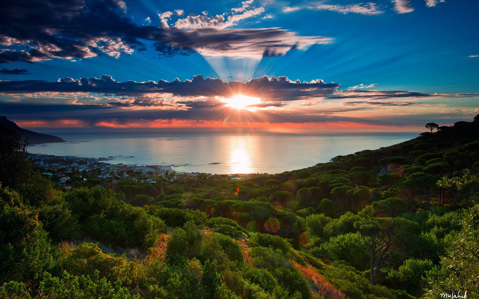 Sunset over the ocean with city and forest HD Wallpaper