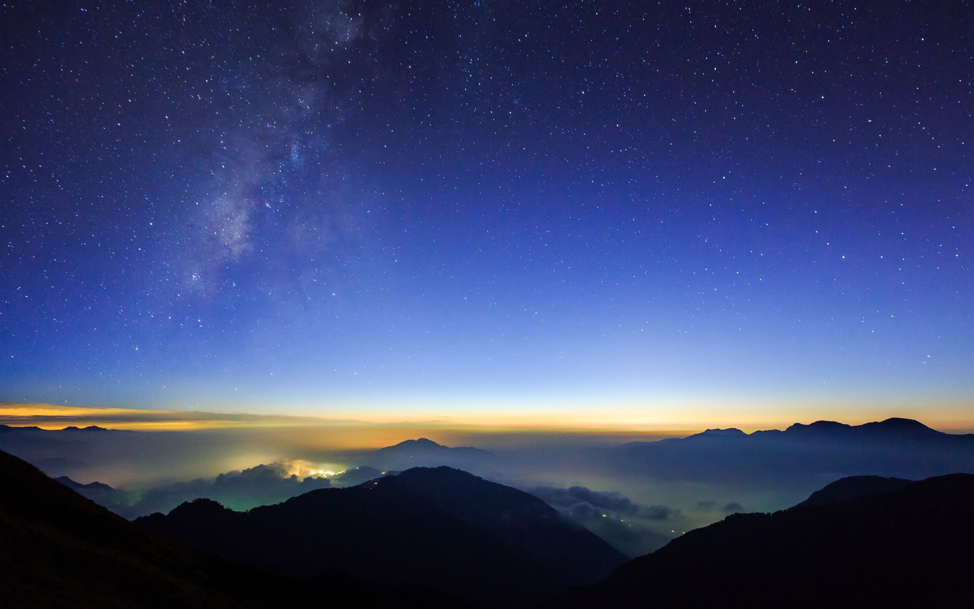 Milky Way over mountains and clouds at night HD Wallpaper
