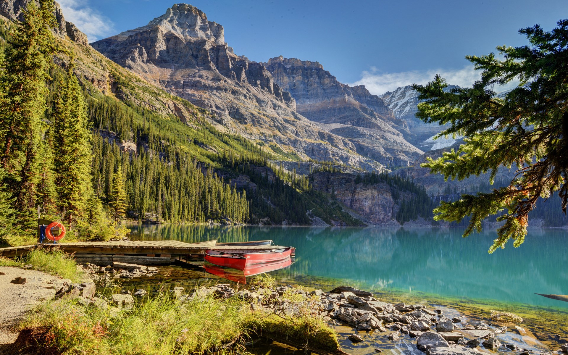 Red canoe on a wooden dock by a mountain lake HD Wallpaper