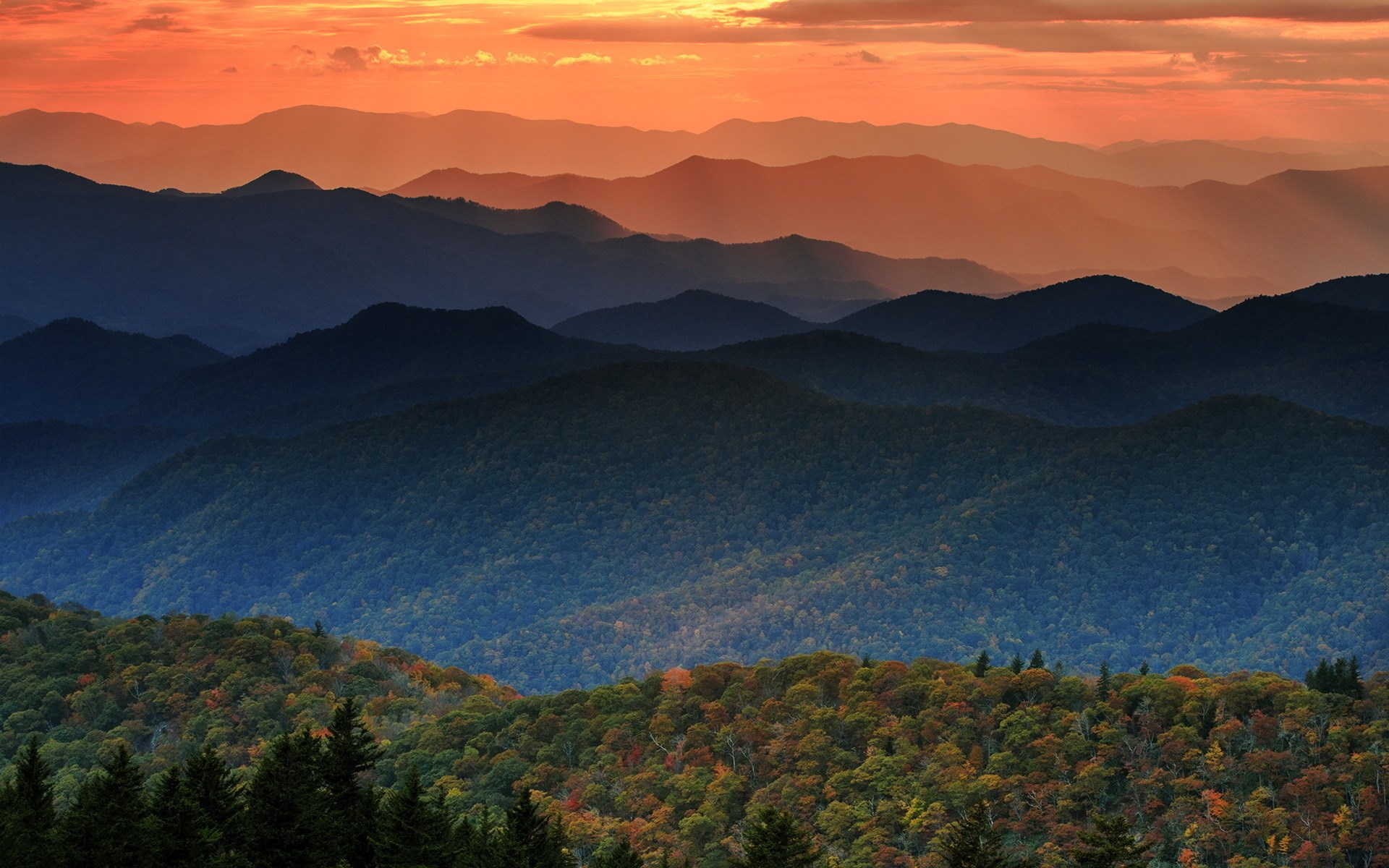 Mountain layers at sunset with orange sky HD Wallpaper