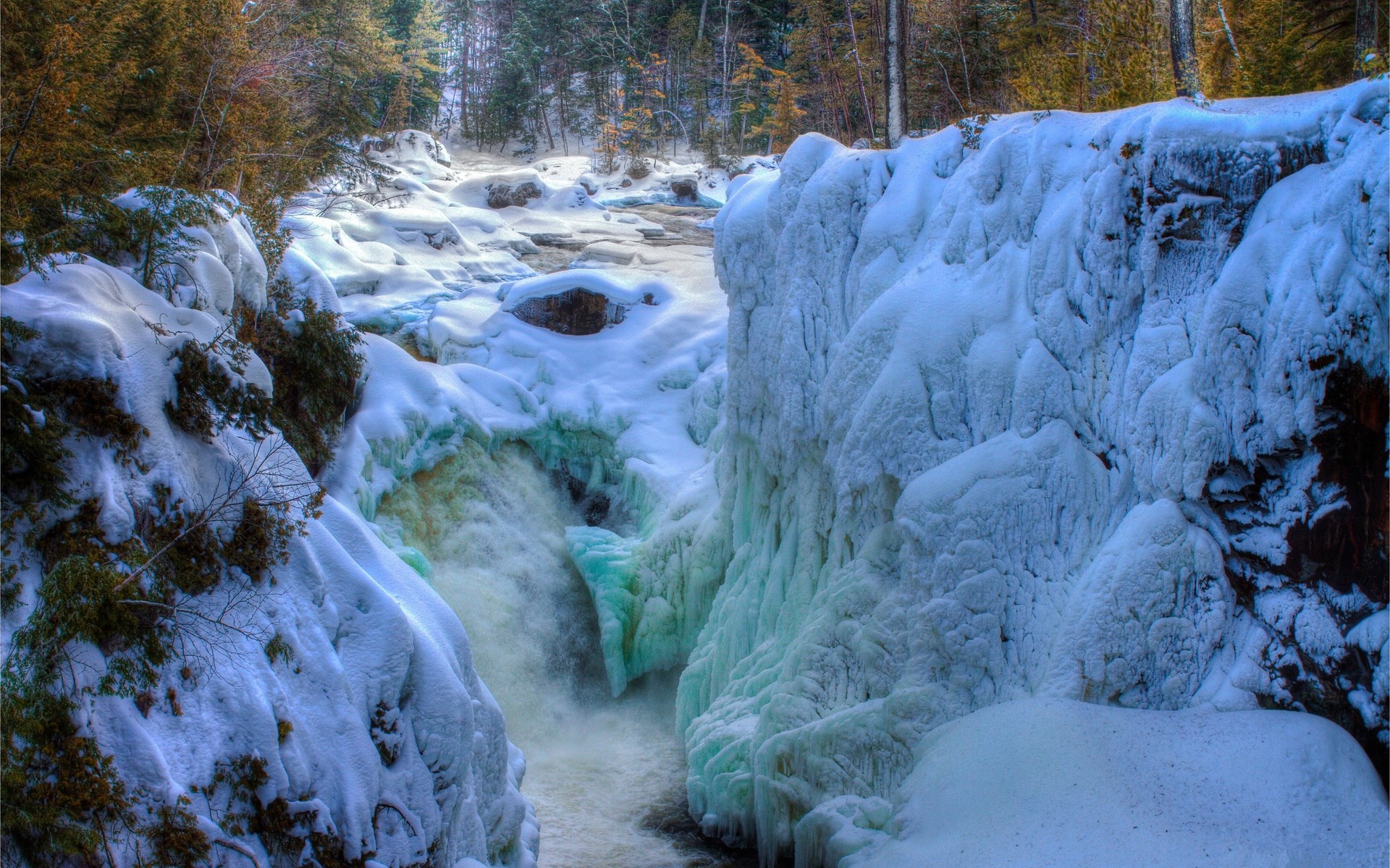 Frozen waterfall in a snowy forest HD Wallpaper