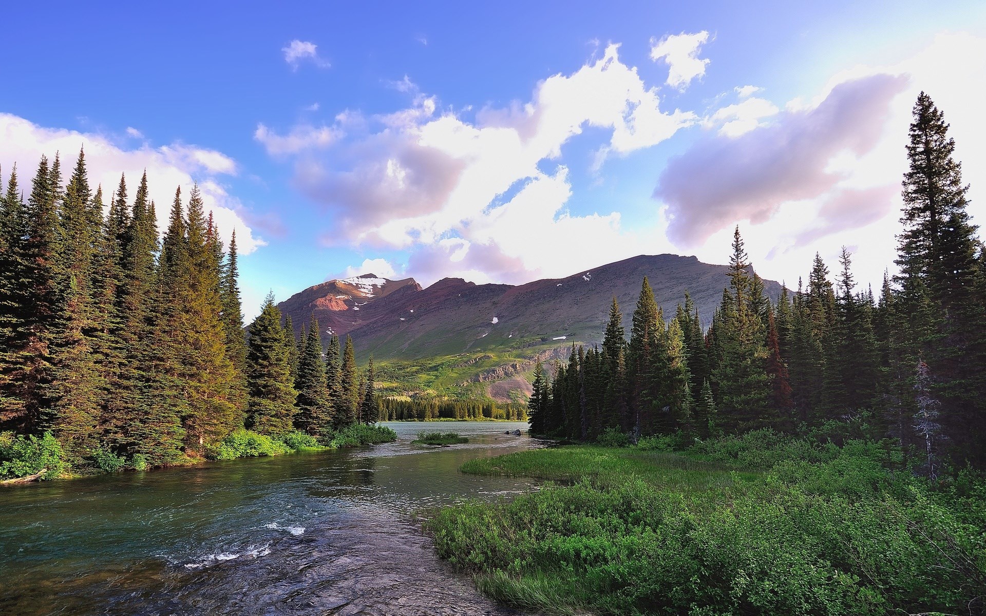 River flowing through a forest with mountains in the background HD Wallpaper