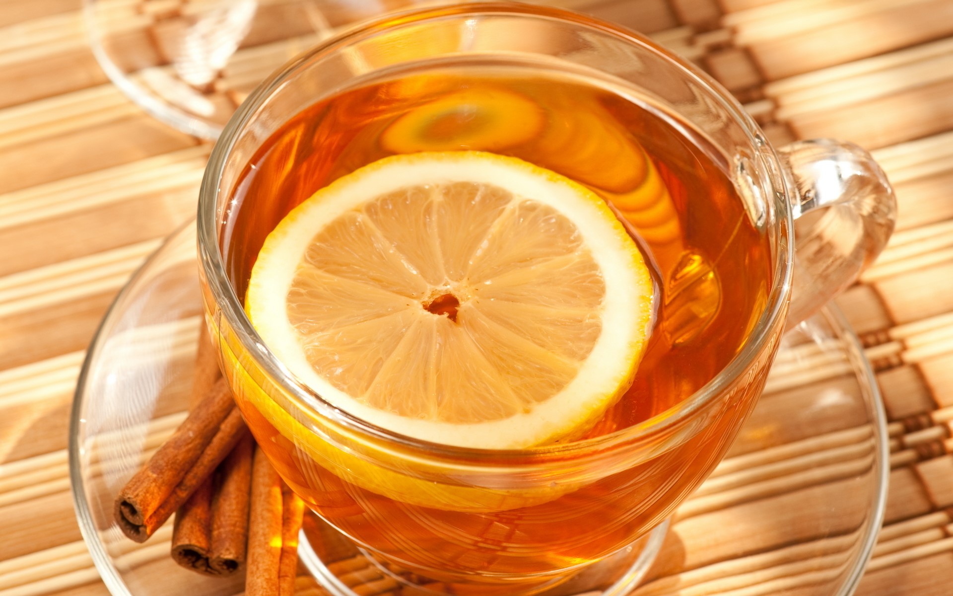 Cup of tea with lemon and cinnamon sticks HD Wallpaper