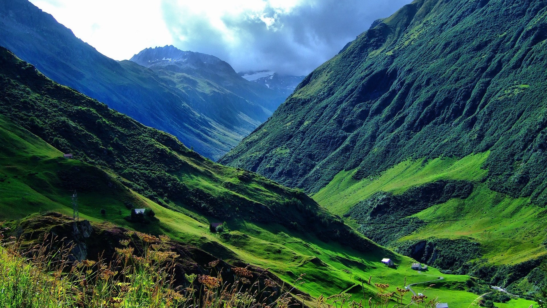 Green mountain valley with small houses HD Wallpaper