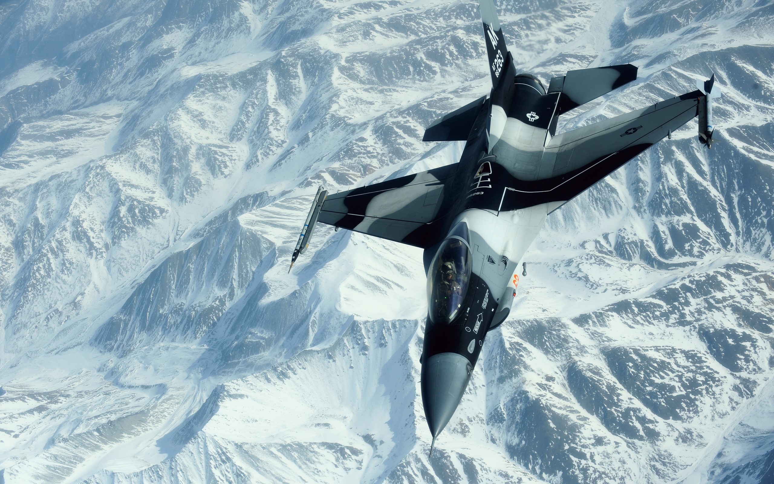 Fighter jet flying over snowy mountains HD Wallpaper