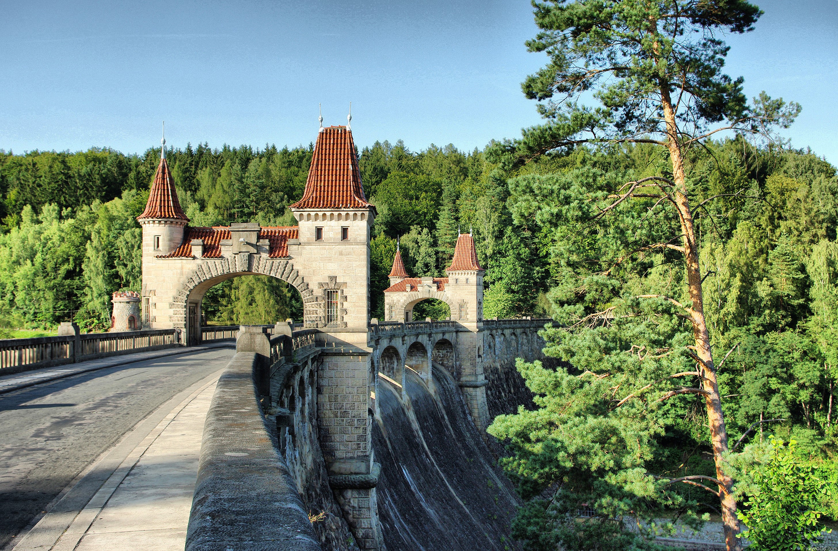 Stone dam with castle-like towers and a forest background HD Wallpaper